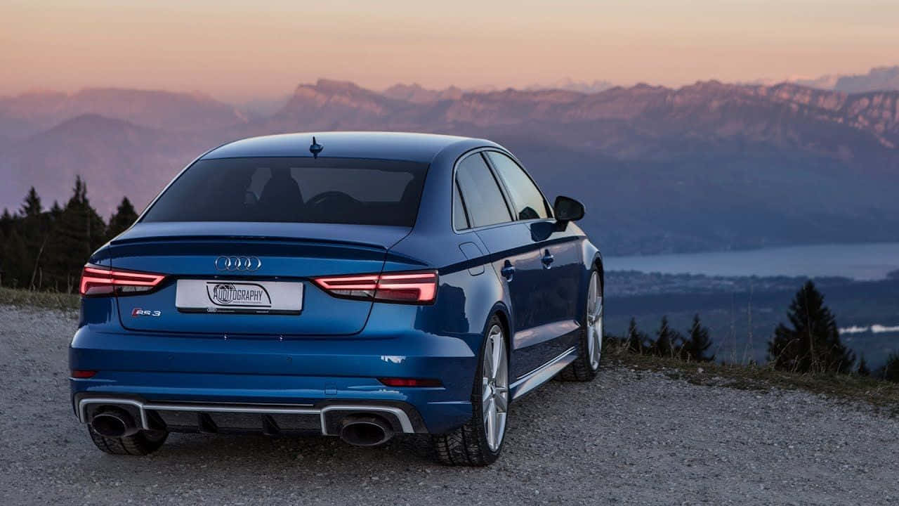 Sedan 桌布 壁紙 — 一台時尚的藍色 Audi RS3 轎車停泊在日落時分的碎石觀景點，背景有山脈和湖泊。