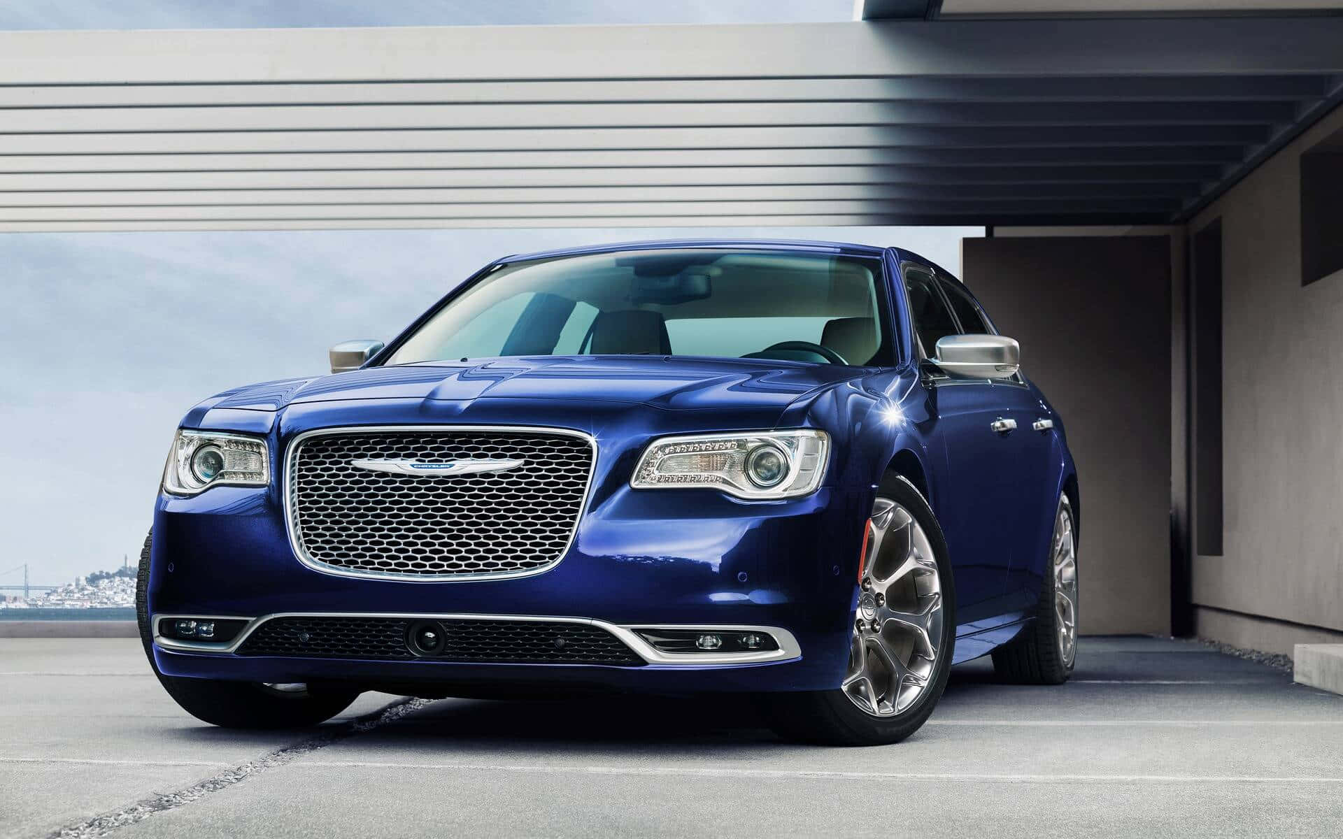 Chrysler 桌布 壁紙 — 一台時尚的藍色克萊斯勒轎車在日光下閃耀，停放在現代混凝土簷篷下。