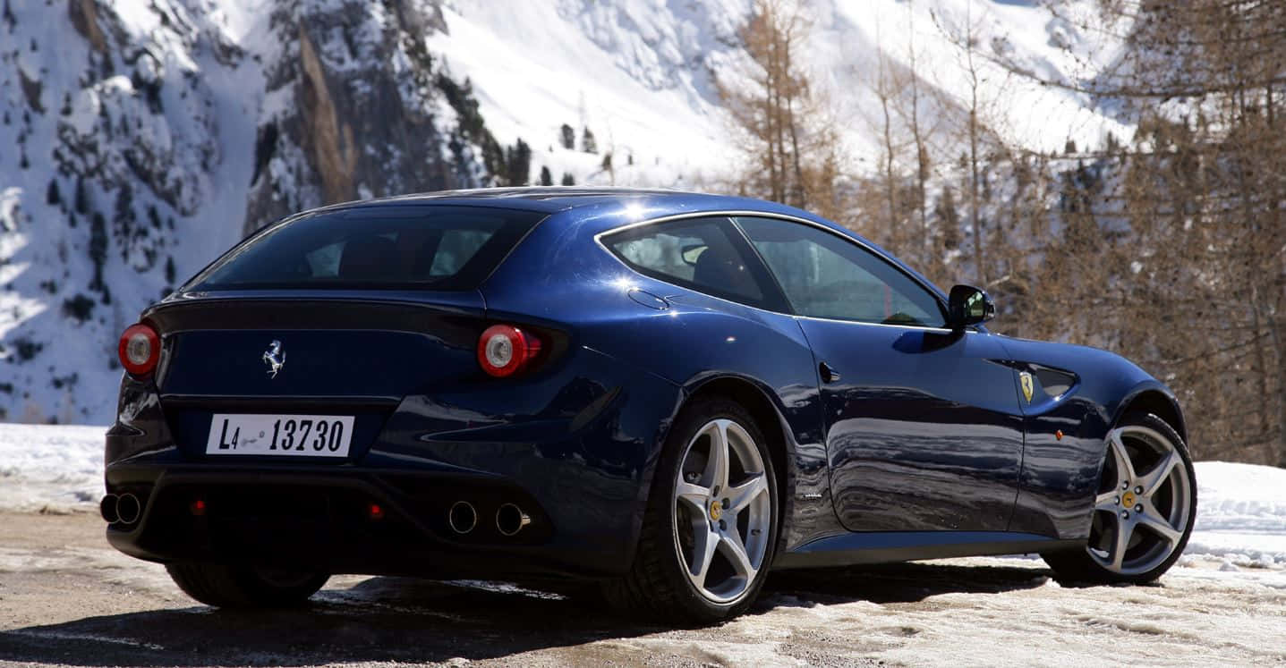 Ferrari Ff 桌布 壁紙 — 一台時尚的藍色法拉利FF停泊在白雪覆蓋的山路上，背景是白雪覆蓋的山峰和光禿禿的樹木。