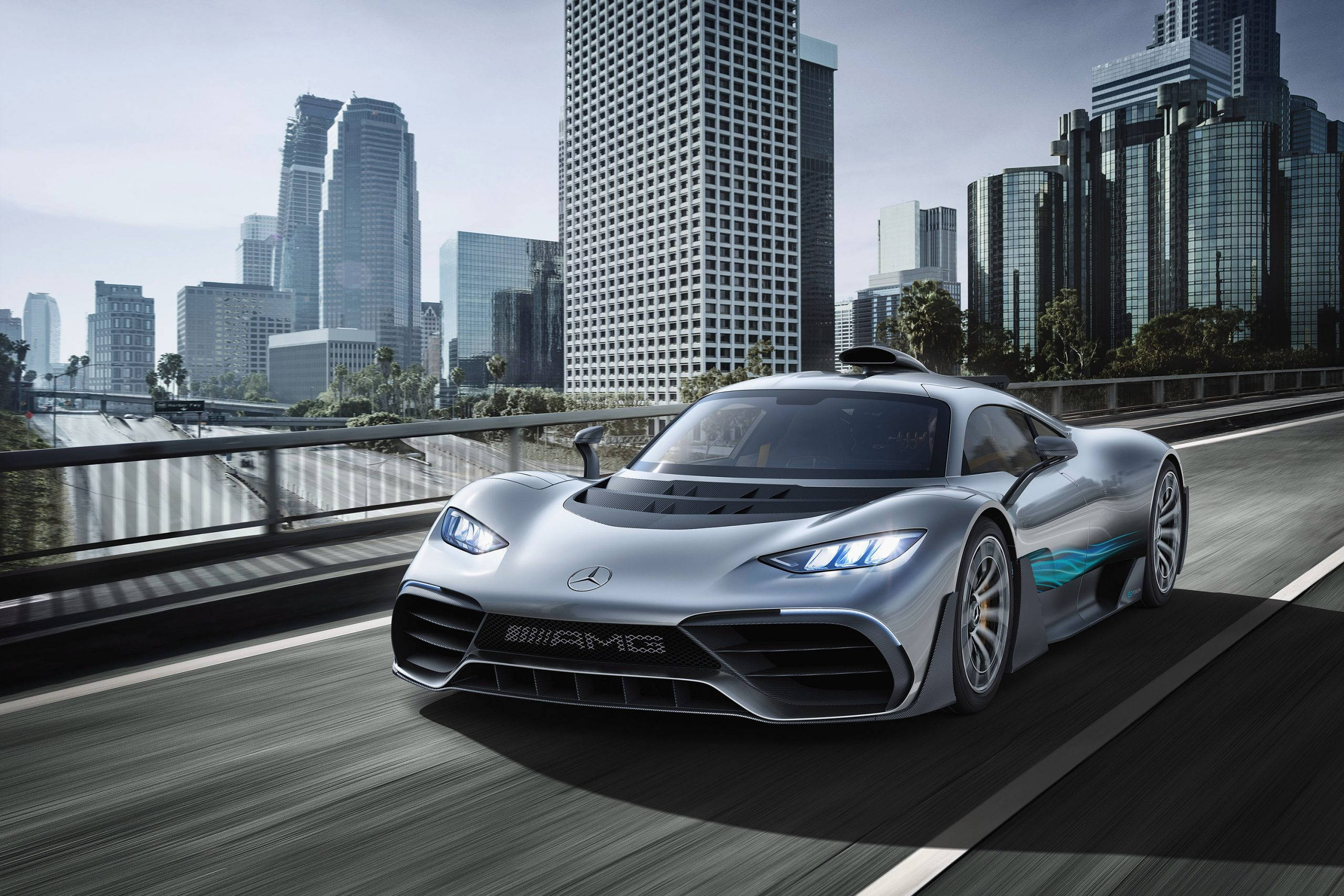 Mercedes Benz Amg 桌布 壁紙 — 一台時尚的銀色 Mercedes-AMG 跑車在都市大橋上奔馳，背景是高聳的摩天大樓。
