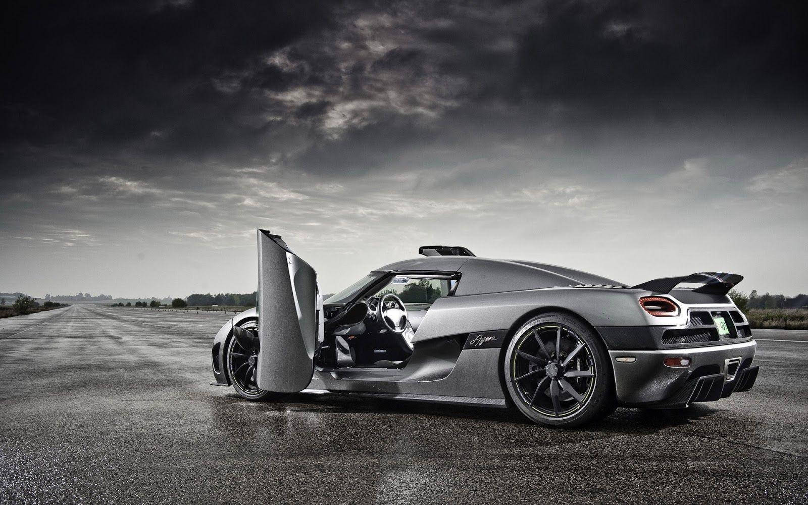 黑白 桌布 壁紙 — 一台時尚的銀色Koenigsegg Agera停在空蕩的柏油路上，剪刀門打開，背景是戲劇性的多雲天空。
