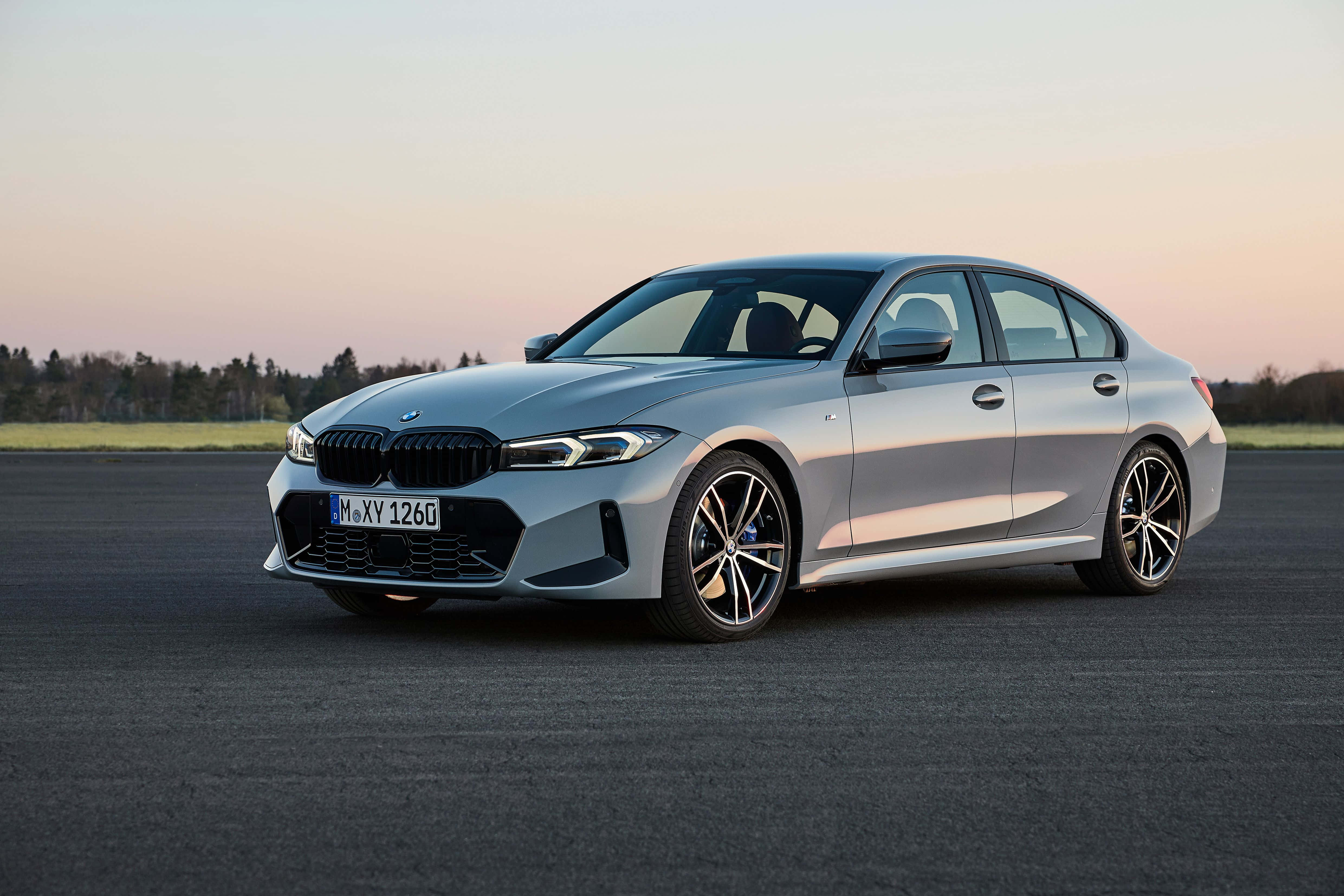Bmw 3 Series 桌布 壁紙 — 一台時尚的銀色寶馬3系列轎車停放在日落時分的柏油路上，背後是柔和的粉紅和橙色天空。