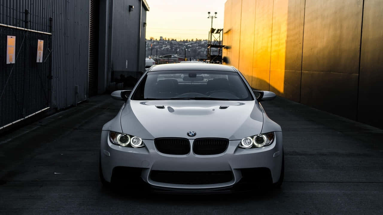 720p Bmw 桌布 壁紙 — 一台時尚的銀色寶馬M3跑車停放在沐浴著金色夕陽光線的小巷中。