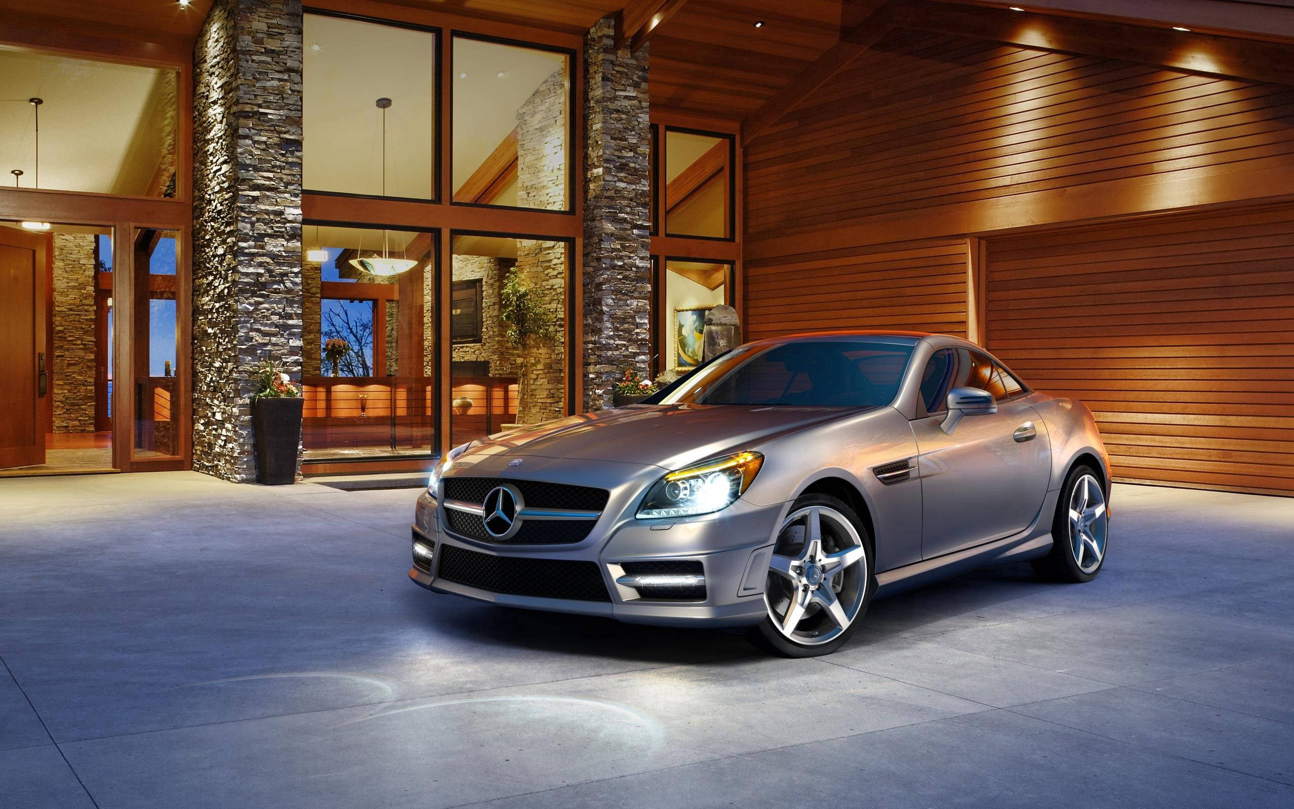 Mercedes 桌布 壁紙 — 一台時尚的銀色梅賽德斯-奔馳SLK跑車在現代木石豪華車庫入口的溫暖燈光下閃閃發光。