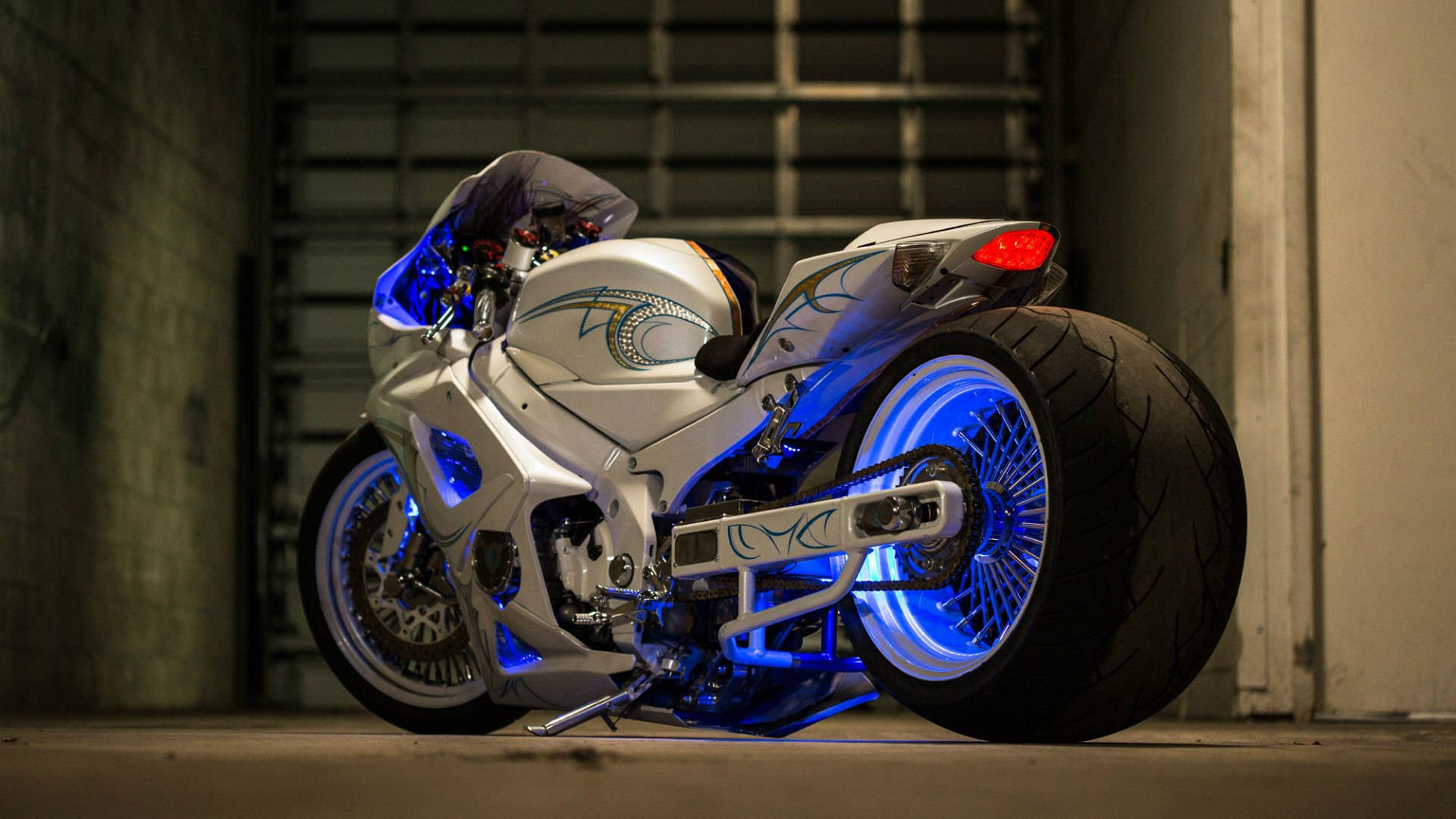Suzuki 桌布 壁紙 — 一台時尚的銀色機車，帶有發光的藍色底盤燈，停放在昏暗的混凝土車庫中。