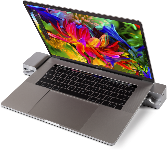 MacBook Pro 桌布 壁紙 — 一台時尚的銀色筆記型電腦，螢幕上顯示充滿活力的抽象花卉桌布，放置在簡約支架上，背景為黑色。
