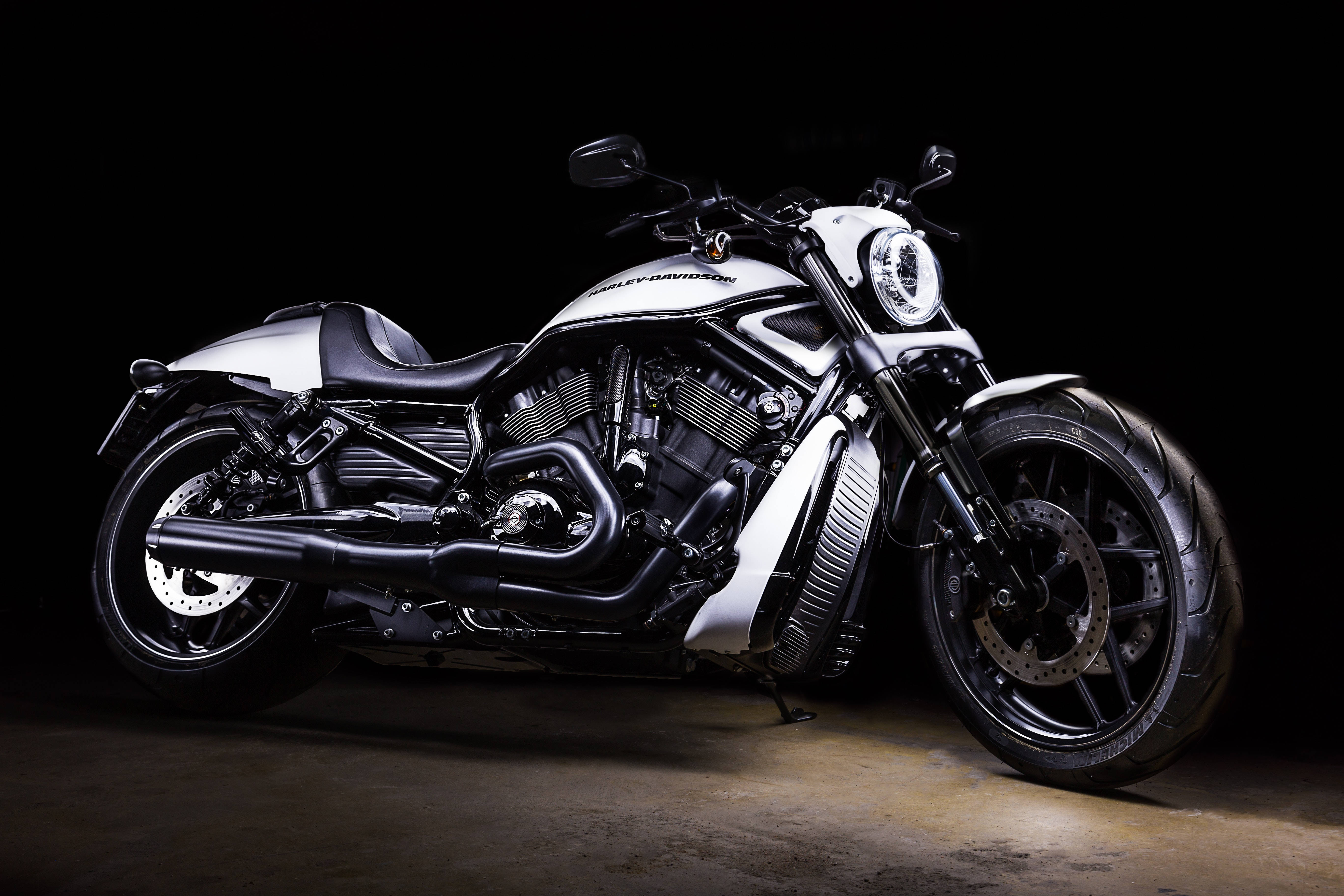 Harley 桌布 壁紙 — 一台時尚的黑白色哈雷戴維森機車在戲劇性的攝影棚燈光下，在漆黑的背景上閃閃發光。
