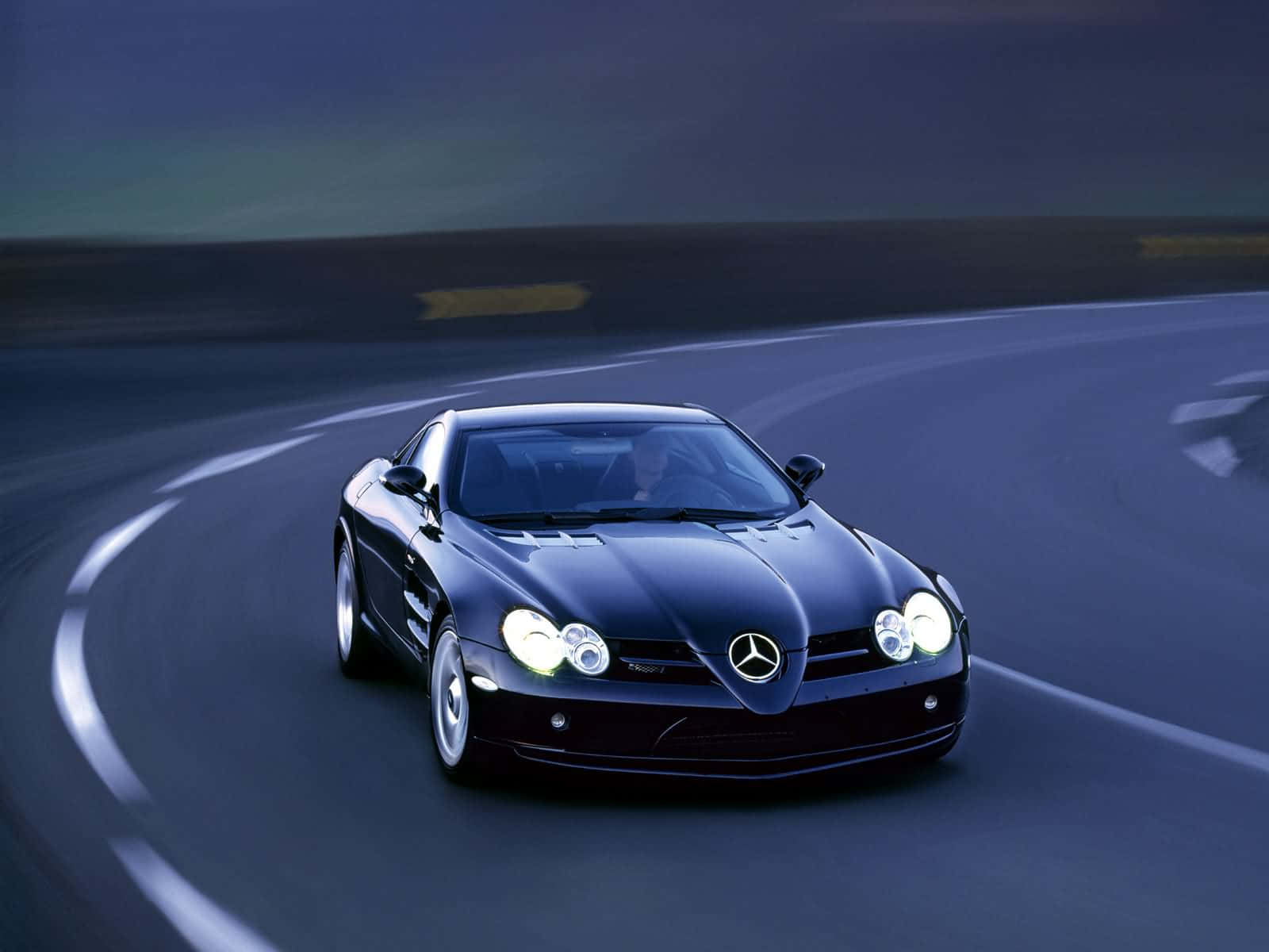 跑車 桌布 壁紙 — 一台時尚的黑色 Mercedes SLR McLaren 在暮色天空下繞著蜿蜒的賽道飛馳。