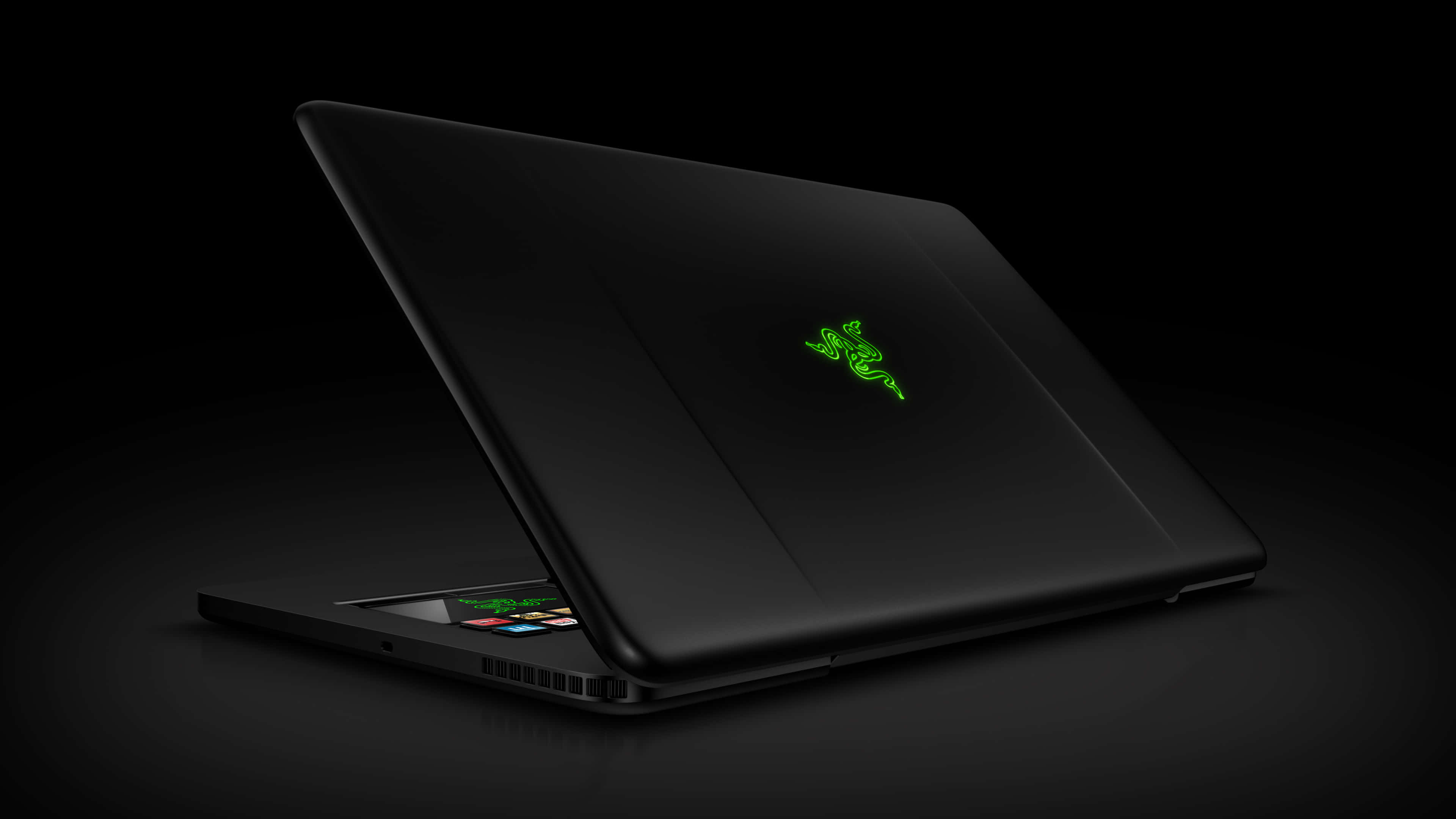 雷蛇 桌布 壁紙 — 一台時尚的黑色 Razer 筆記型電腦，帶有發光的綠色標誌，在黑暗背景下打開。