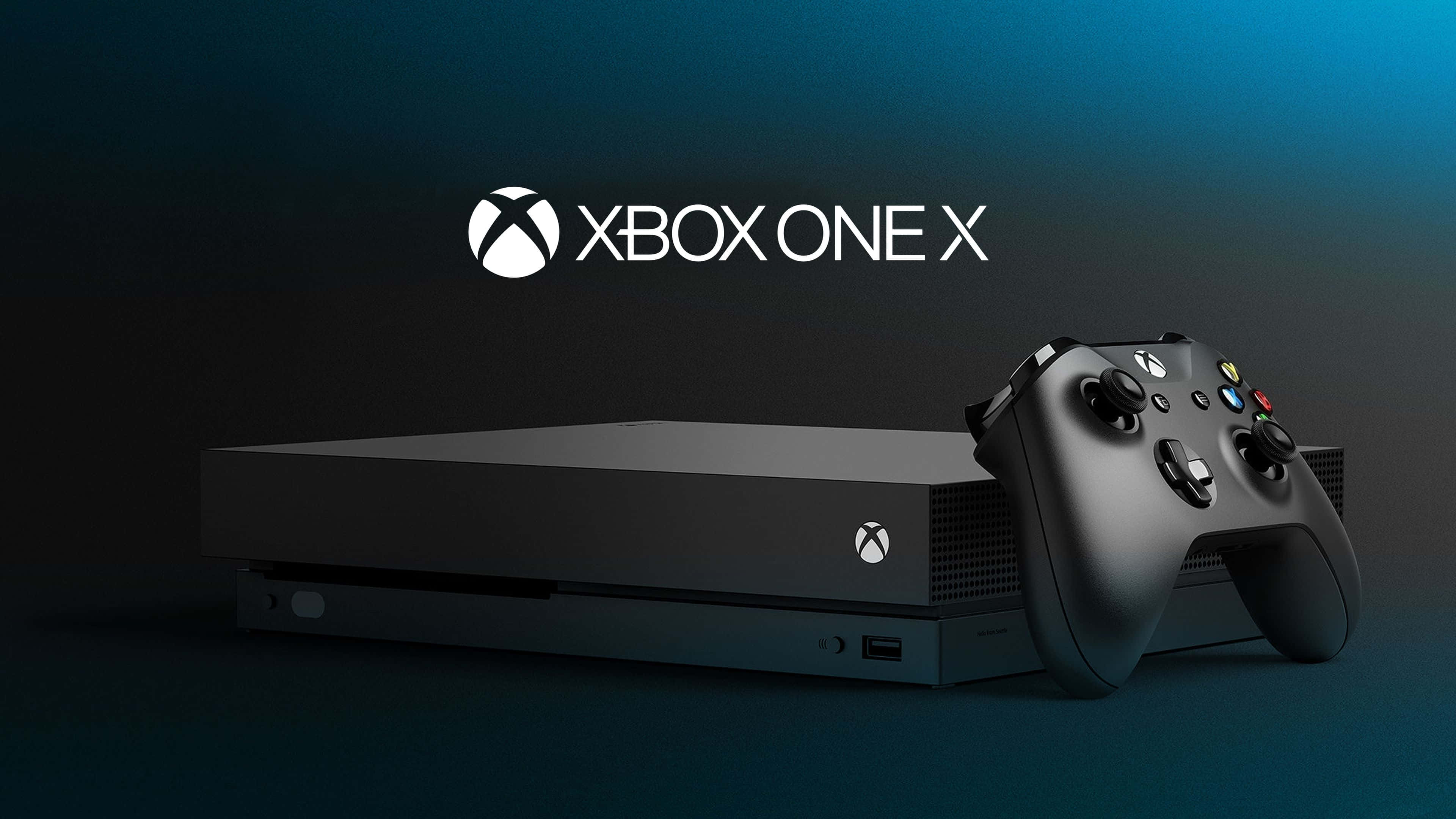 4K Gaming Consoles 桌布 壁紙 — 一台時尚的黑色 Xbox One X 主機和控制器，放置在帶有發光標誌的漸變藍色背景上。