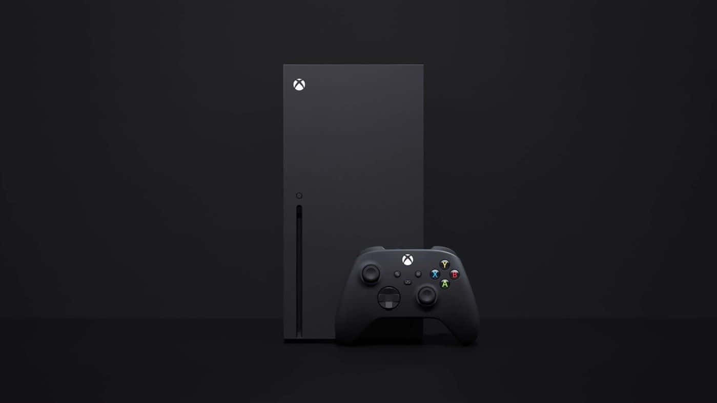 Xbox 桌布 壁紙 — 一台時尚的黑色 Xbox Series X 主機和控制器，在簡約的深色背景和柔和的工作室燈光下展現。