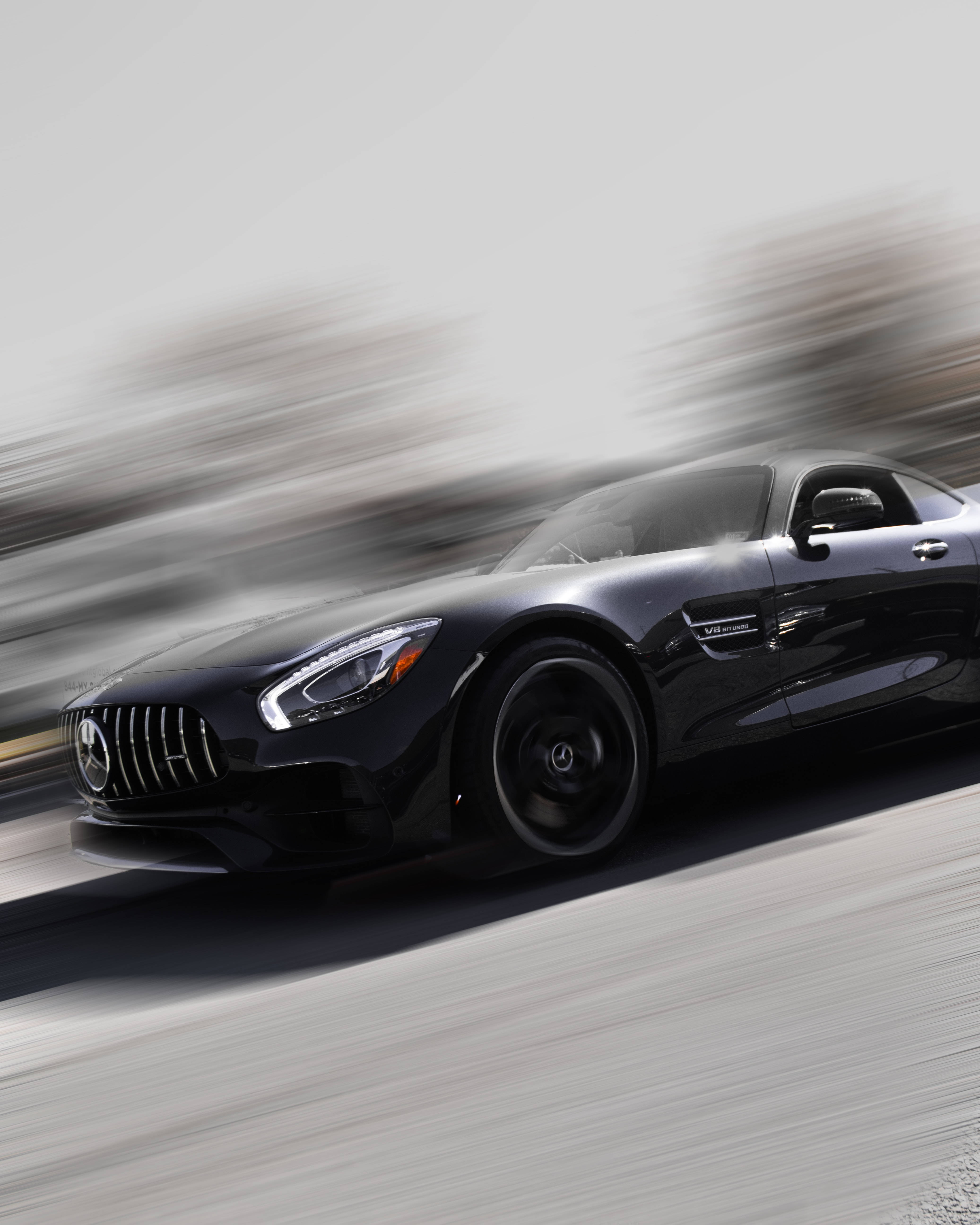 Gtr 桌布 壁紙 — 一台時尚的黑色Mercedes-AMG GT在道路上疾馳，背景帶有動態模糊效果。