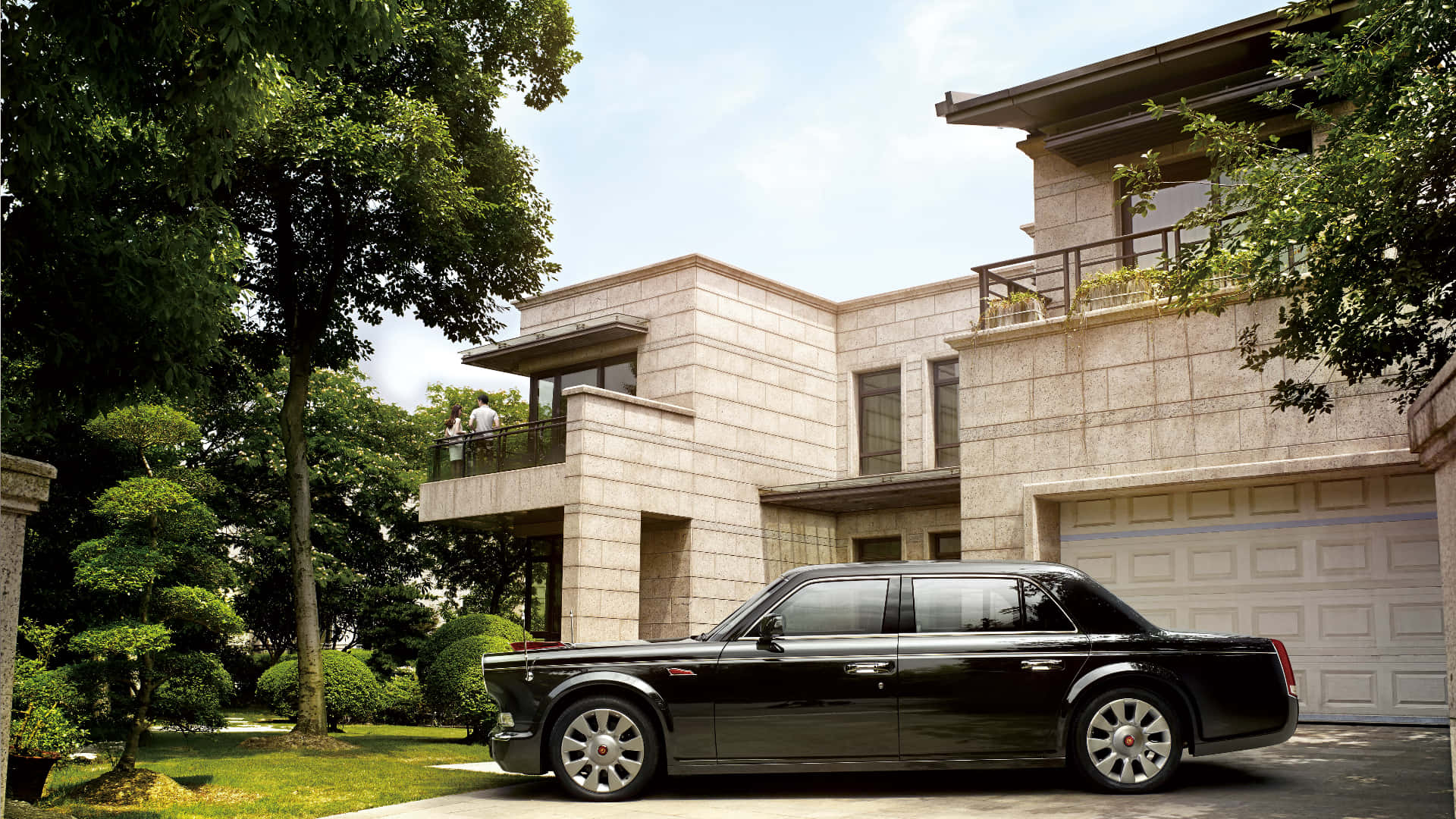 Hongqi 桌布 壁紙 — 一台時尚的黑色勞斯萊斯幻影停在一座現代石砌豪宅前，周圍環繞著茂密的綠植，天空明亮。