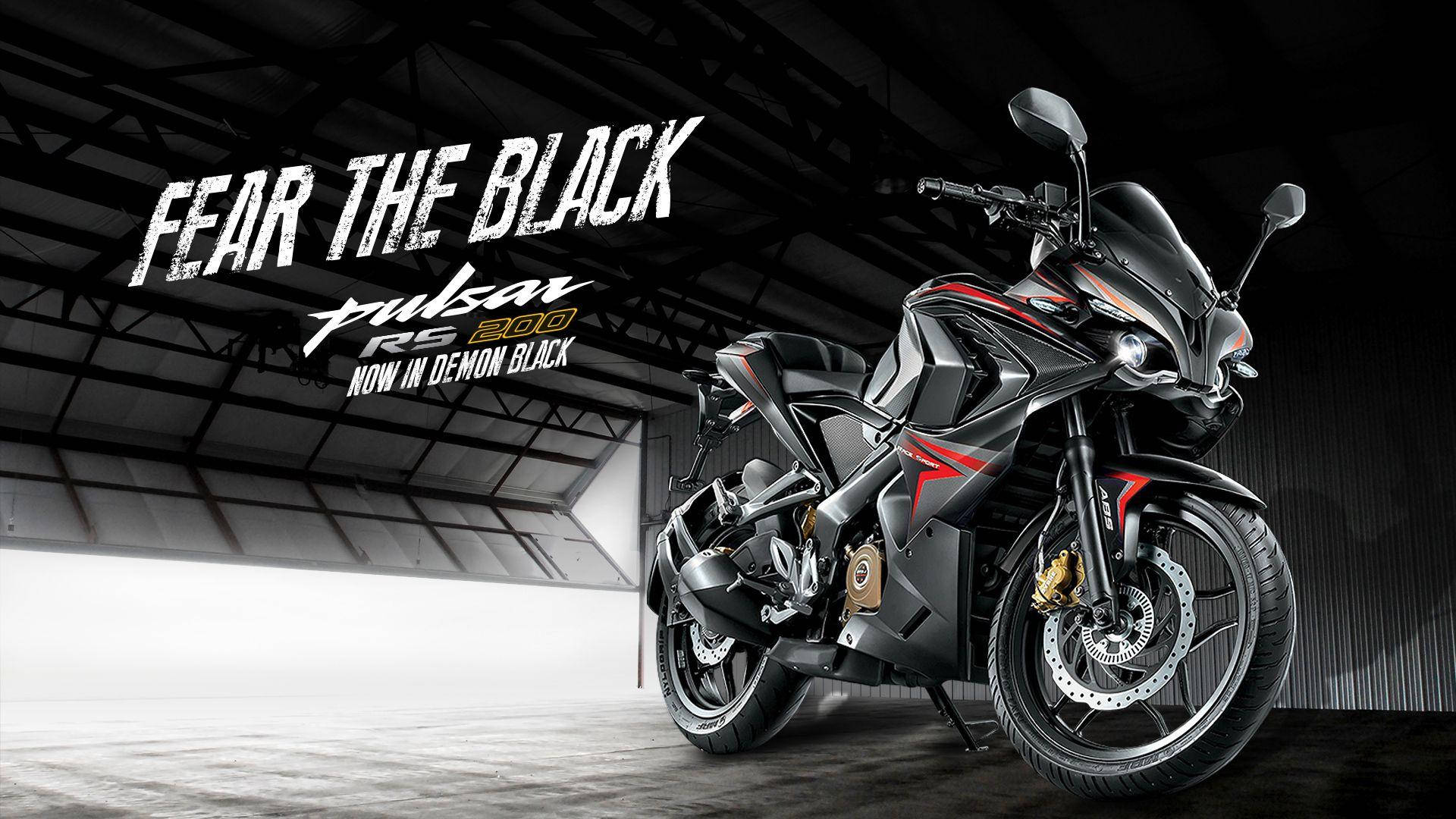 Racing 桌布 壁紙 — 一台時尚的黑色和紅色Pulsar RS 200摩托車戲劇性地停在燈光昏暗的工業車庫中，並以粗體文字宣示「FEAR THE BLACK」。