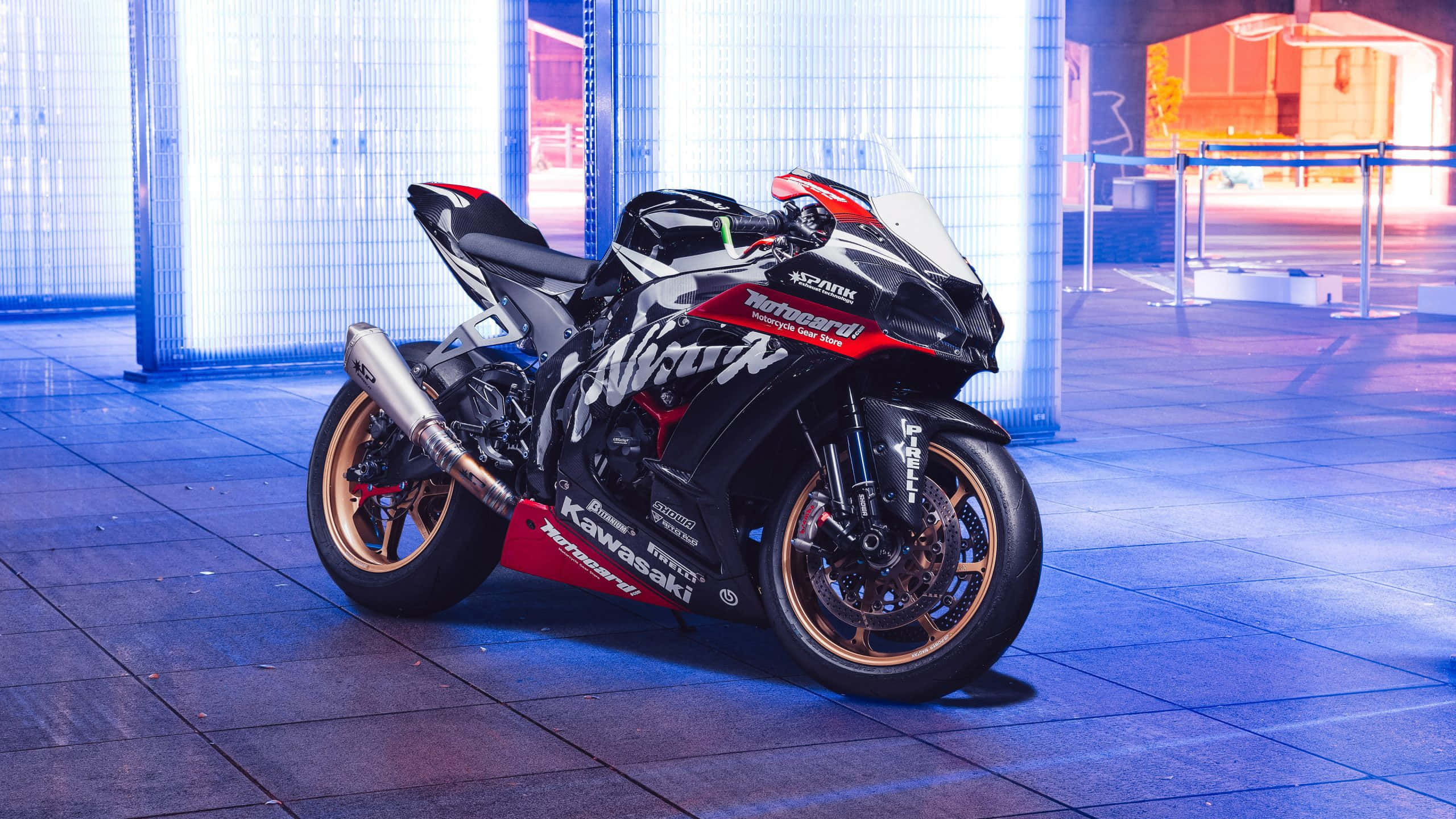 Superbike 桌布 壁紙 — 一台時尚的黑色和紅色川崎忍者運動機車在夜晚的瓷磚城市廣場上，在霓虹綠燈光下閃閃發光。
