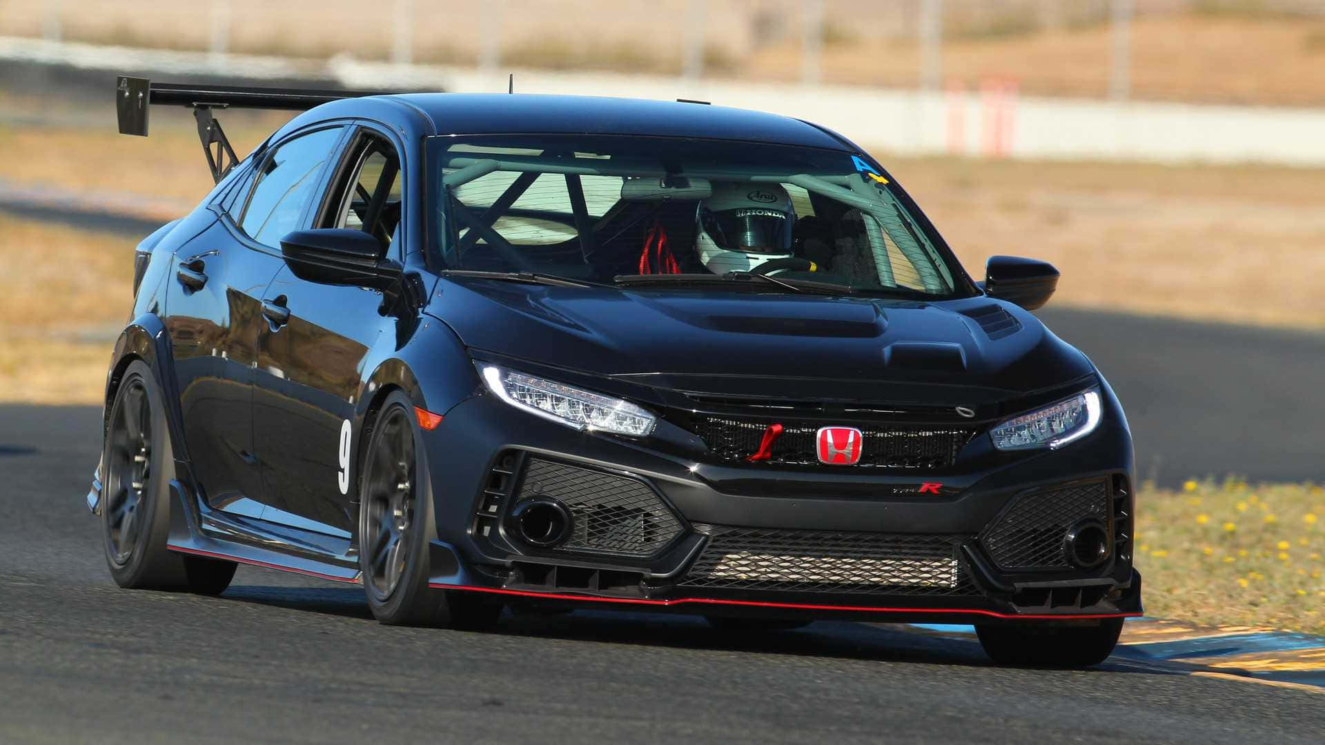 Hatchback 桌布 壁紙 — 一台時尚的黑色本田Civic Type R賽車，帶有紅色點綴，在陽光明媚的賽道上奔馳。