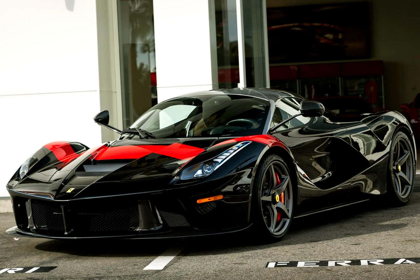 Ferrari Laferrari 桌布 壁紙 — 一台時尚的黑色法拉利LaFerrari帶有醒目紅色點綴，在明亮的日光下閃耀，停放在現代化經銷商前。