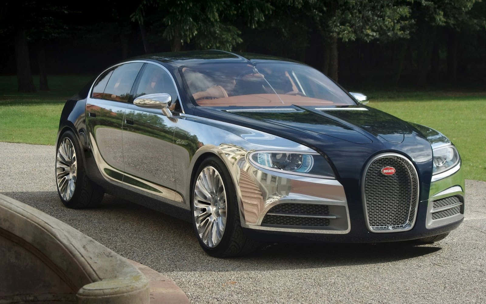 Top 10 Car 桌布 壁紙 — 一台時尚黑色Bugatti Grand Sport Vitesse在日光下閃耀，停在碎石路上，旁邊是翠綠的草地和樹木。