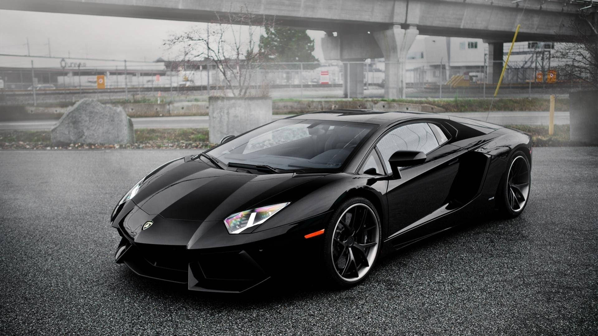 Lamborghini 4K 桌布 壁紙 — 一台時尚黑色藍寶堅尼Aventador停放在潮濕的瀝青路上，天橋下，背景是霧氣瀰漫的城市。