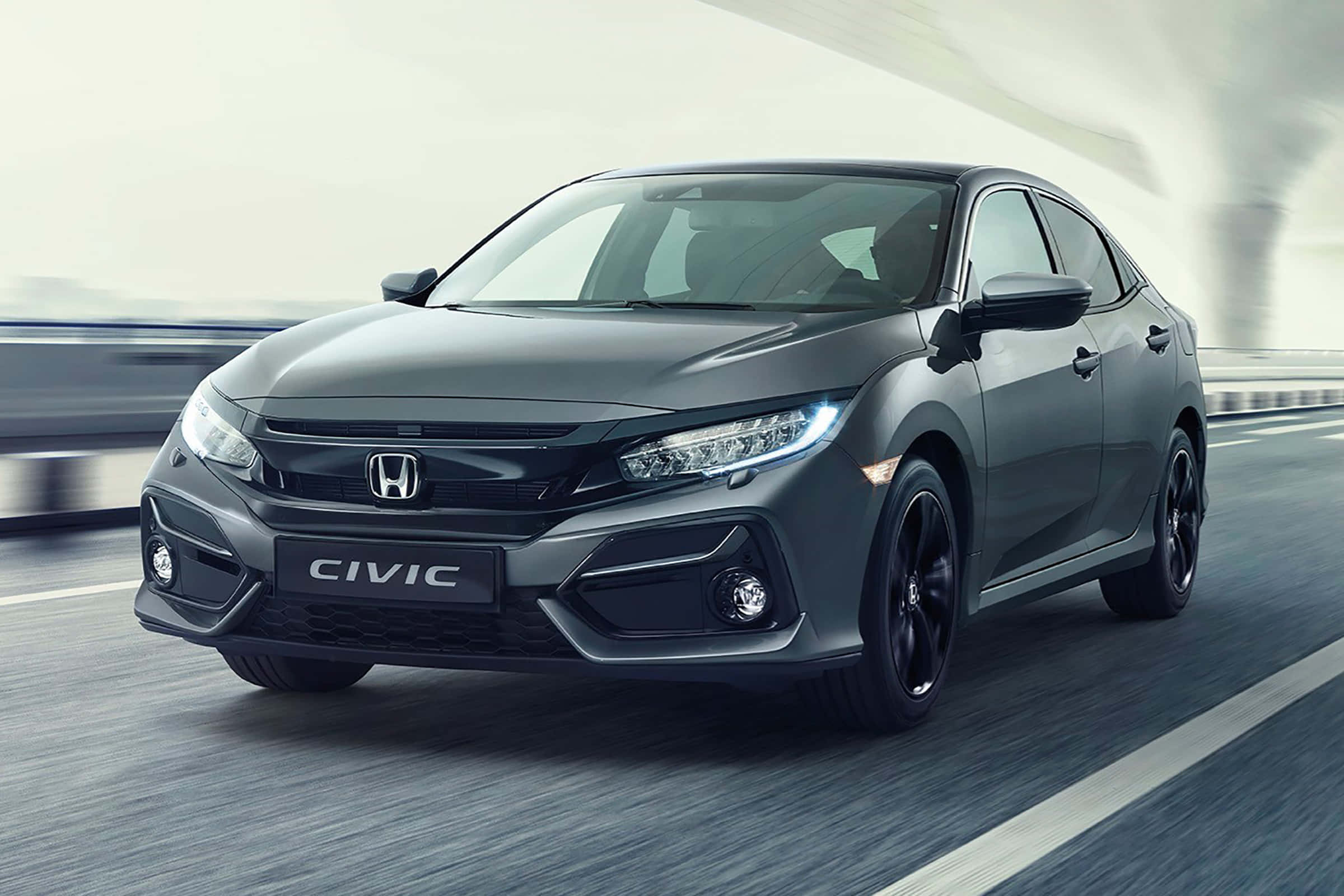 Honda Civic 桌布 壁紙 — 一台流線型灰色本田思域在明亮天空下，沿著模糊的高速公路奔馳，動態模糊強調了速度。