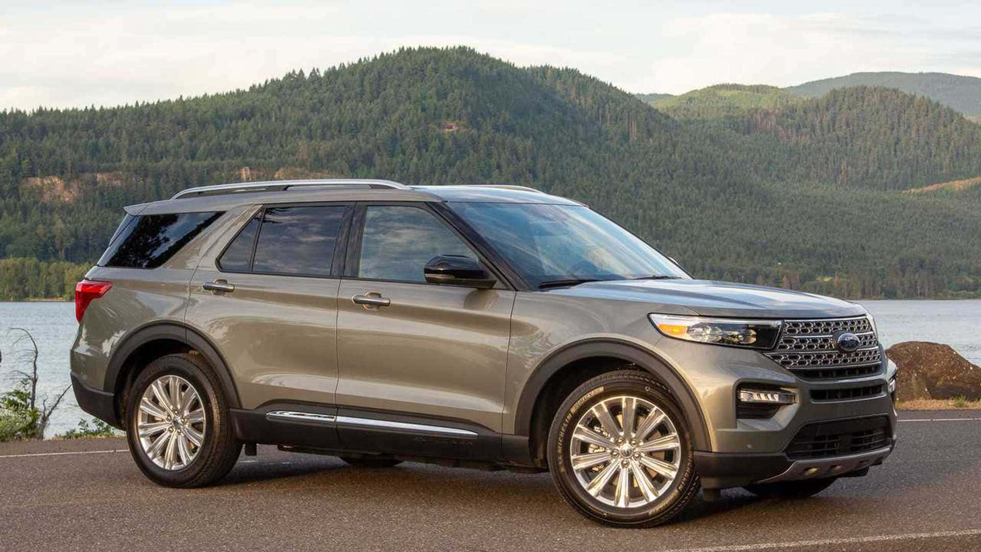 Ford Explorer 桌布 壁紙 — 一台流線型灰色福特探險者SUV停泊在路邊，俯瞰著一個平靜的湖泊，背景是樹木繁茂的山丘。