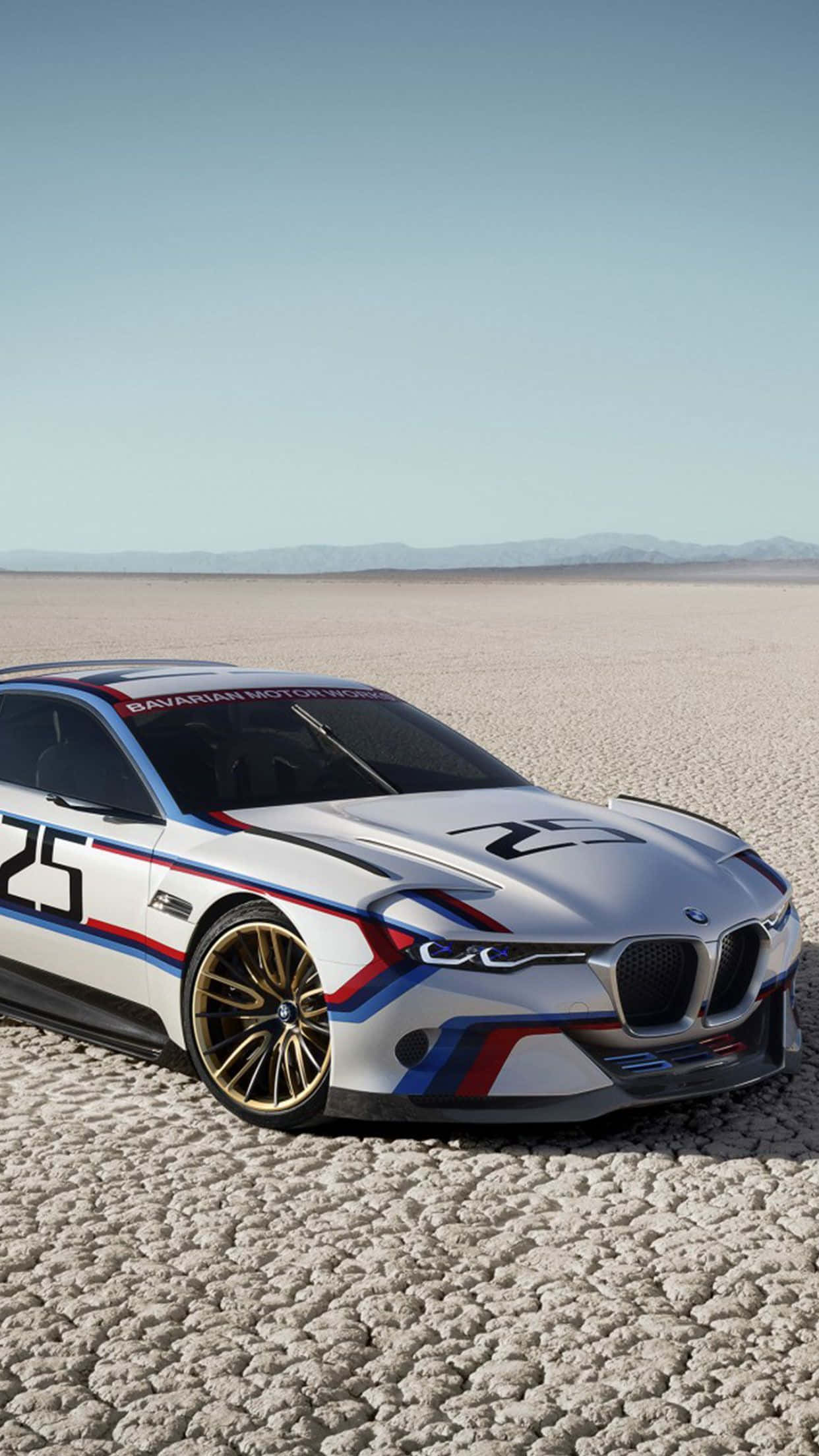 Bmw Android 桌布 壁紙 — 一台流線型白色BMW賽車，帶有藍紅配色和25號標誌，停在晴朗天空下龜裂的鹽灘上。
