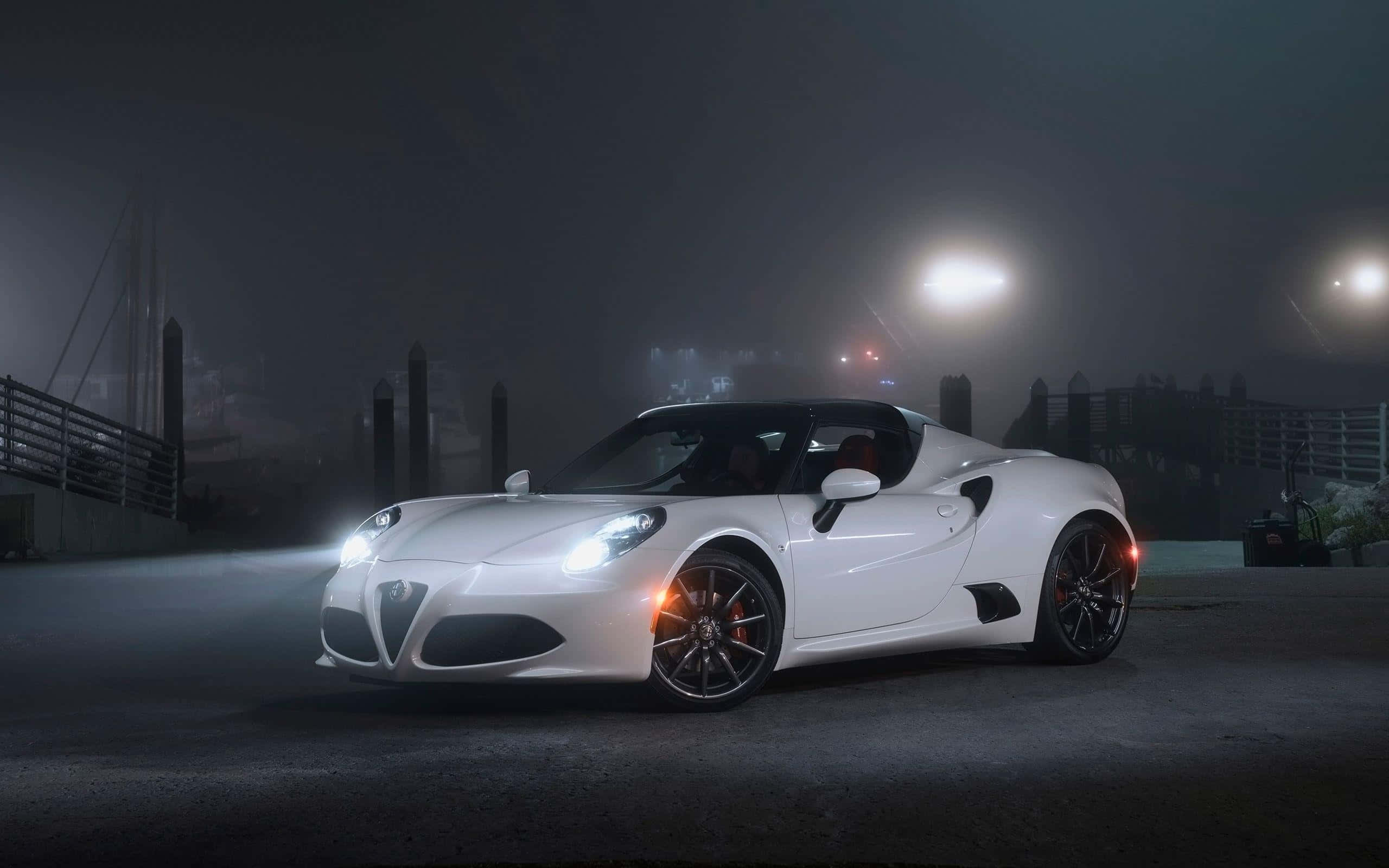 Alfa Romeo 4c 桌布 壁紙 — 一台流線型白色愛快羅密歐跑車在霧夜的海濱碼頭街燈下閃耀。
