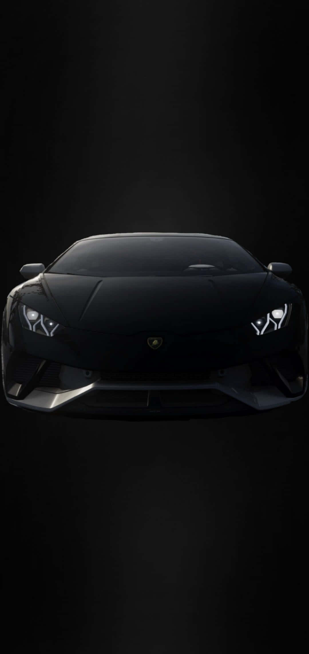 Neon Lamborghini 桌布 壁紙 — 一台流線型的黑色藍寶堅尼跑車，在漆黑一片的虛空中閃爍著銳利的車頭燈。