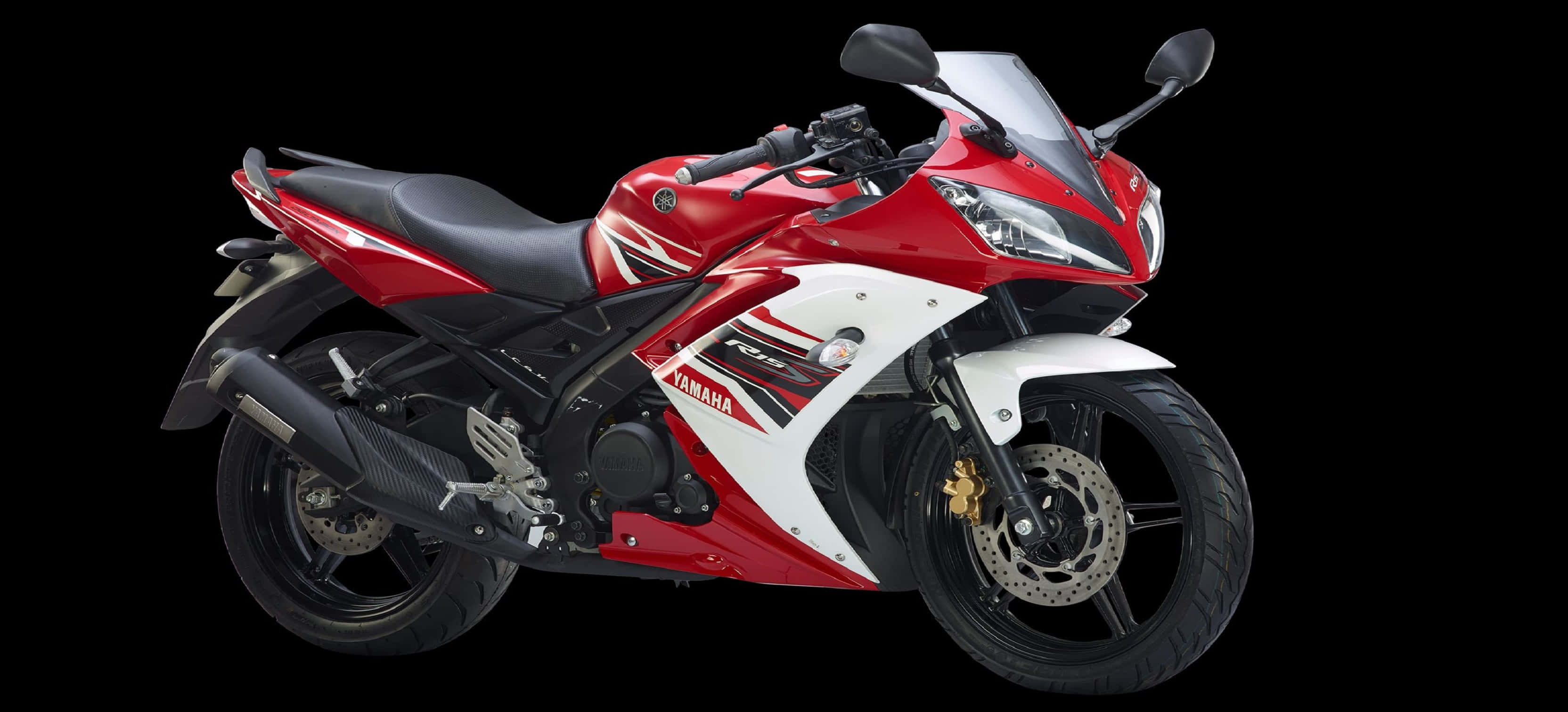 R15 桌布 壁紙 — 一台流線型紅白Yamaha R15運動機車，帶有黑色點綴和金色煞車卡鉗，在純黑色背景上孤立展示。