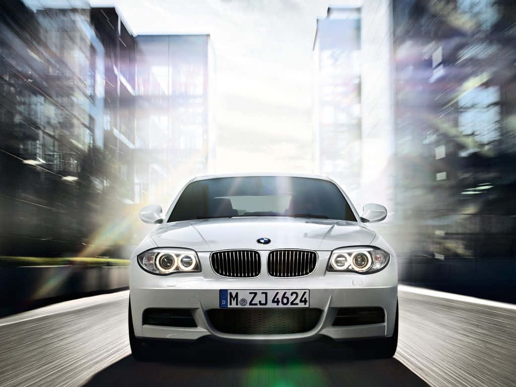 Bmw 1 Series 桌布 壁紙 — 一台流線型銀色寶馬在模糊的城市峽谷中疾馳，帶有動態條紋和明亮的鏡頭光暈。