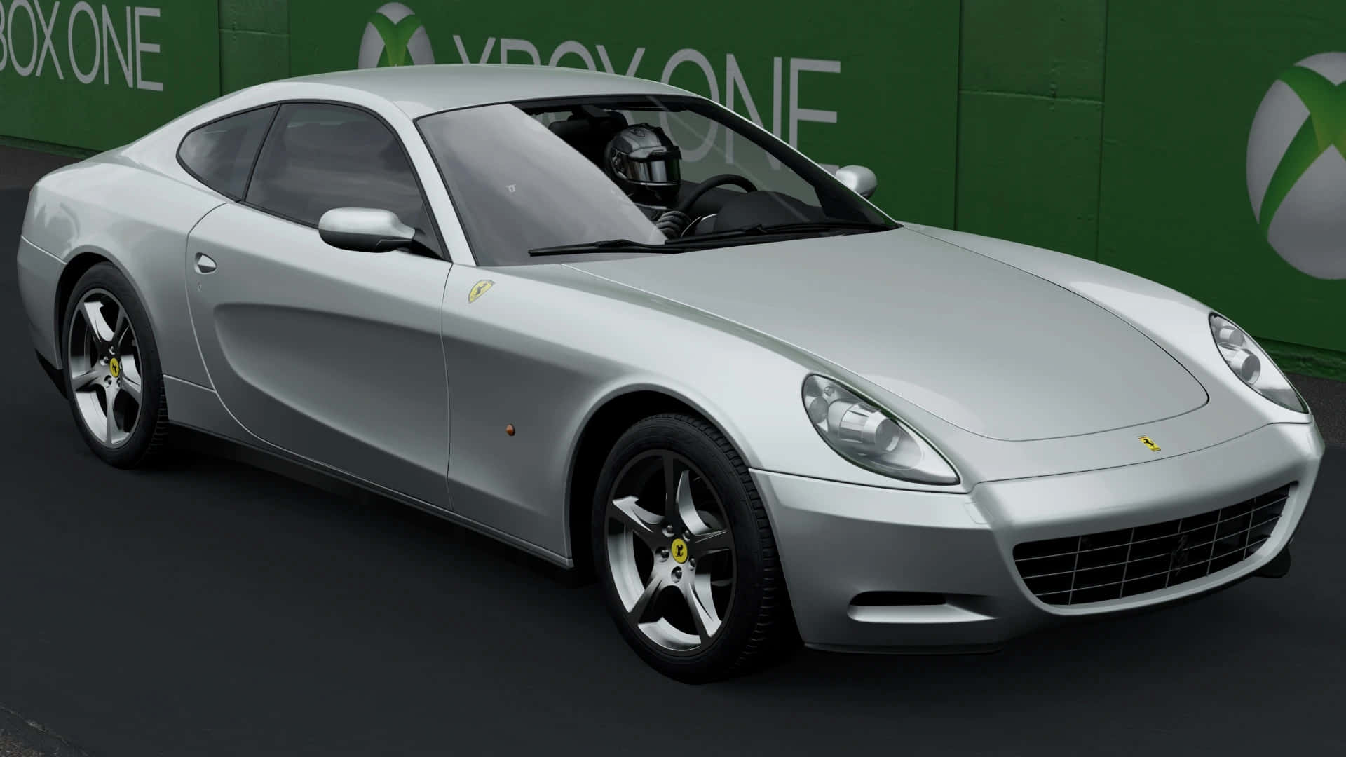 Ferrari 612 Scaglietti 桌布 壁紙 — 一台流線型銀色法拉利跑車，司機戴著頭盔，停在綠色Xbox One品牌牆前。