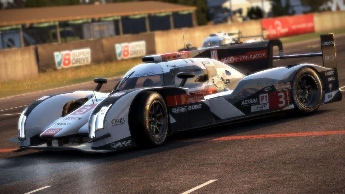1366x768 Project Cars 2 桌布 壁紙 — 一台流線型銀黑色奧迪 R18 e-tron quattro 賽車在陽光明媚的賽道上疾馳，後面緊跟著另一輛車。