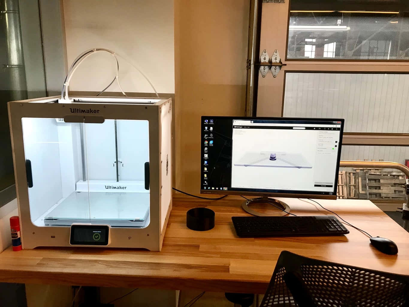 3d Printer 桌布 壁紙 — 一台白色 Ultimaker 3D 印表機放在木桌上，旁邊的電腦顯示著一個用於列印的 3D 模型。