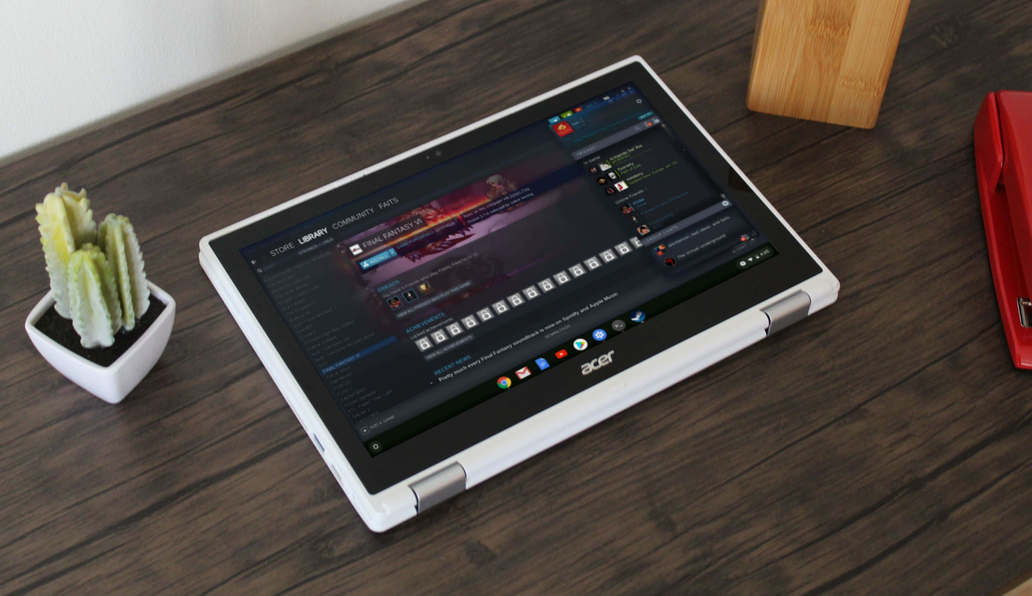 Chromebook 桌布 壁紙 — 一台白色Acer平板電腦放在深色木桌上，旁邊有一個小仙人掌和紅色釘書機。