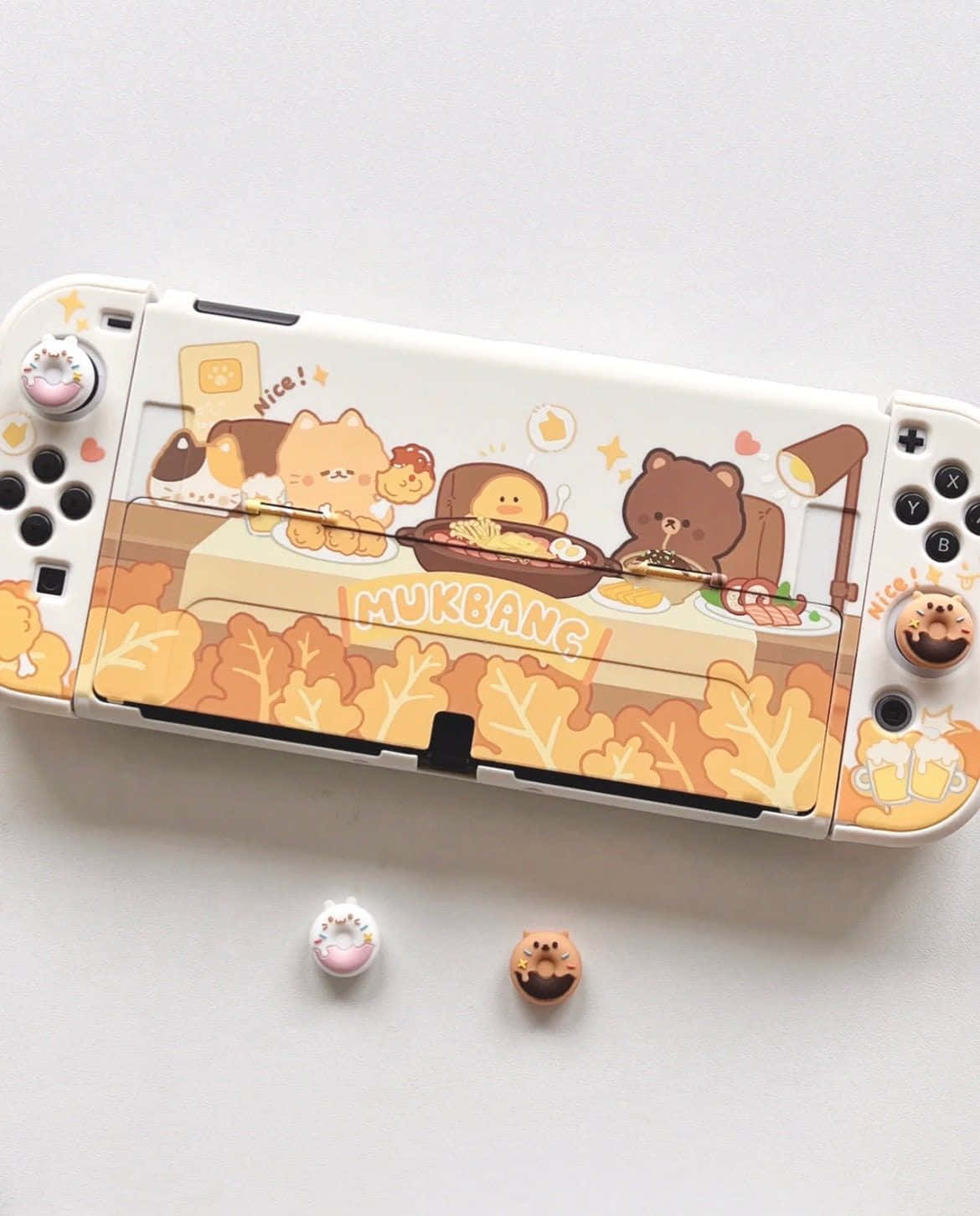 用遊戲主機模擬器，在桌機上重溫經典遊戲！ 壁紙 — 一台白色Nintendo Switch，配上可愛的吃播主題自訂保護殼，上面有卡通動物在秋葉環繞下吃東西。