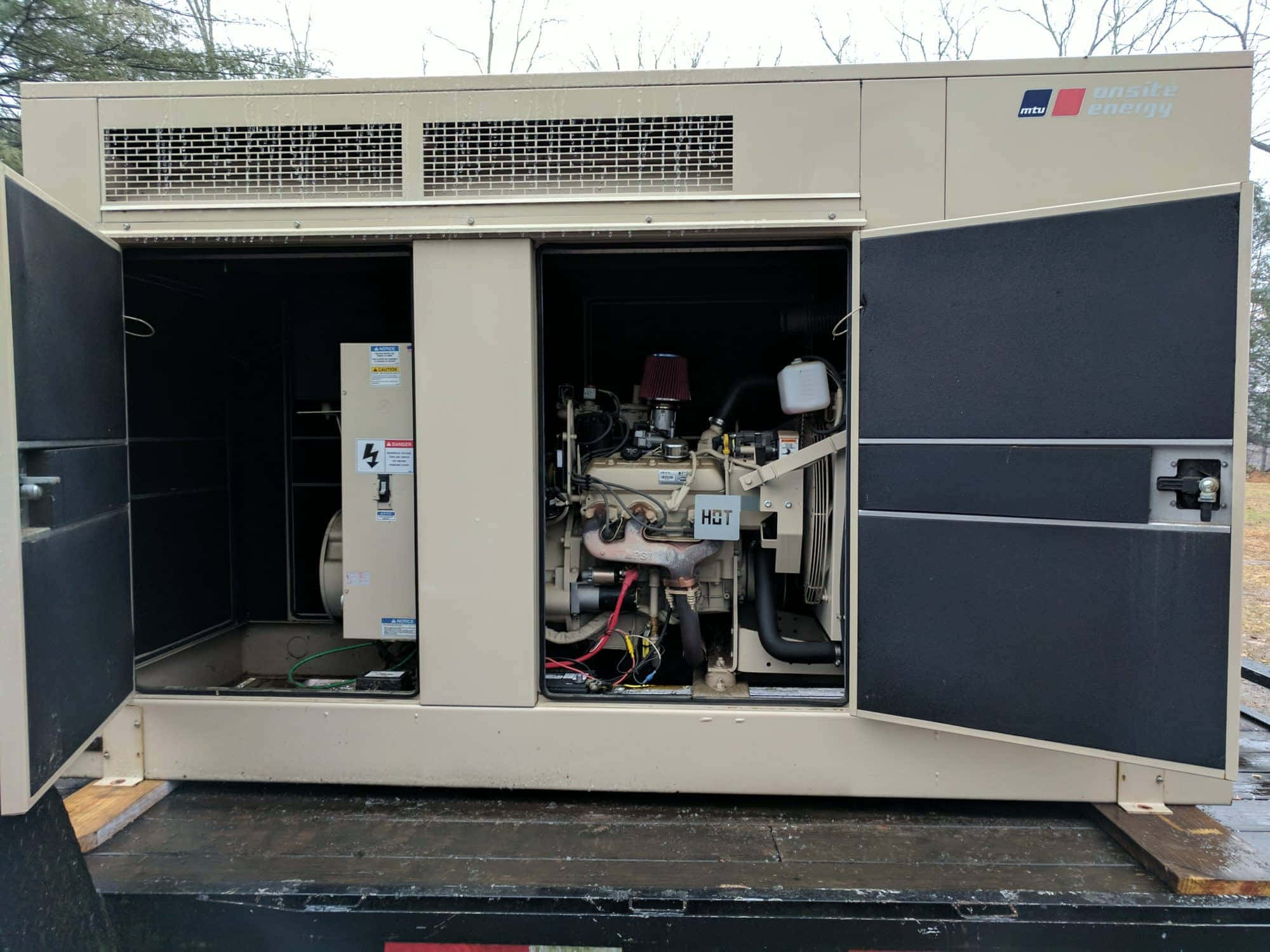 引擎 桌布 壁紙 — 一台米色 MTU Onsite Energy 發電機，門打開露出引擎和零件，放在室外卡車車斗上。