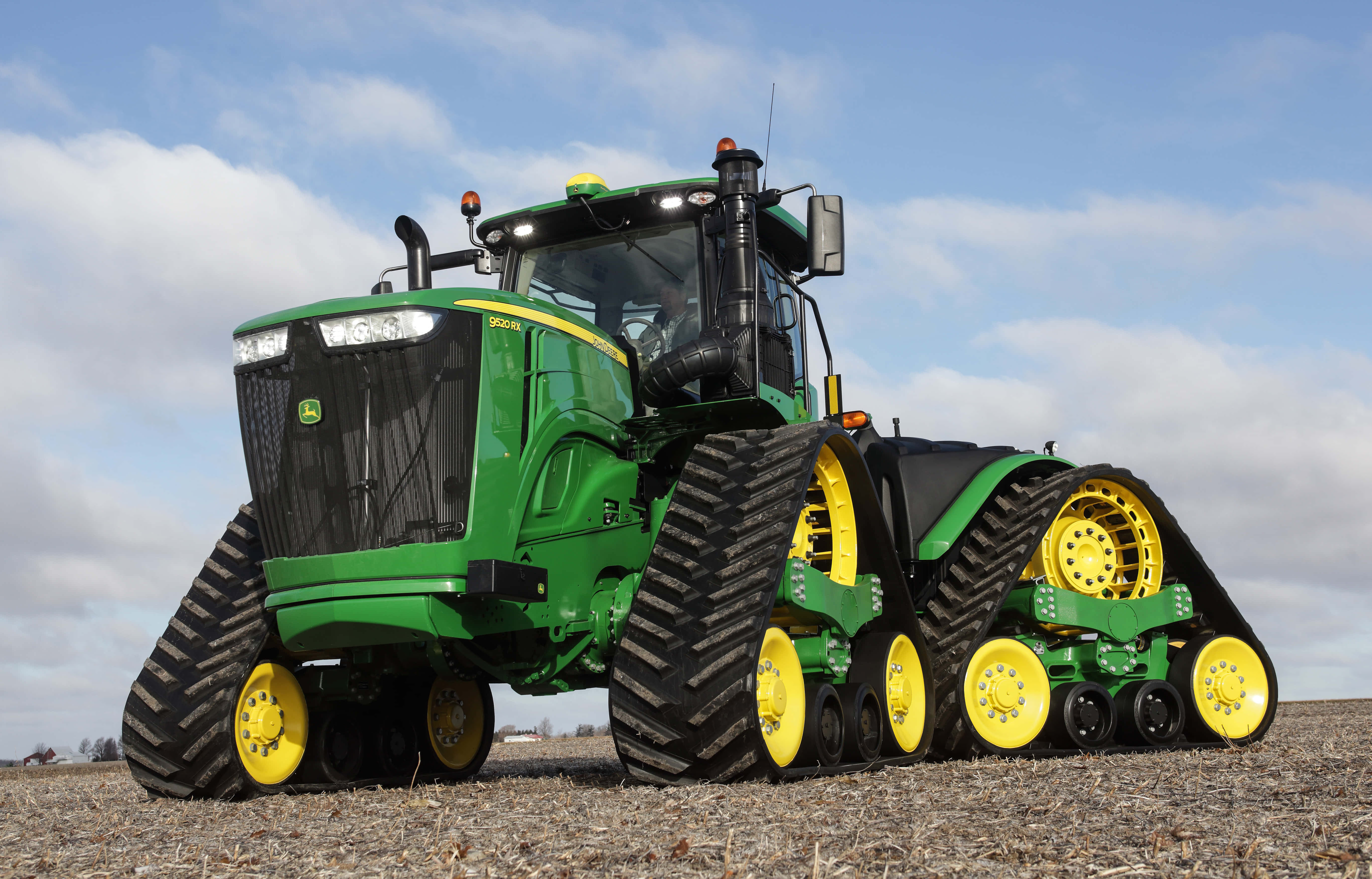 Tractor 桌布 壁紙 — 一台綠色和黃色的John Deere履帶拖拉機在陰天下的乾燥田野上強力地矗立。