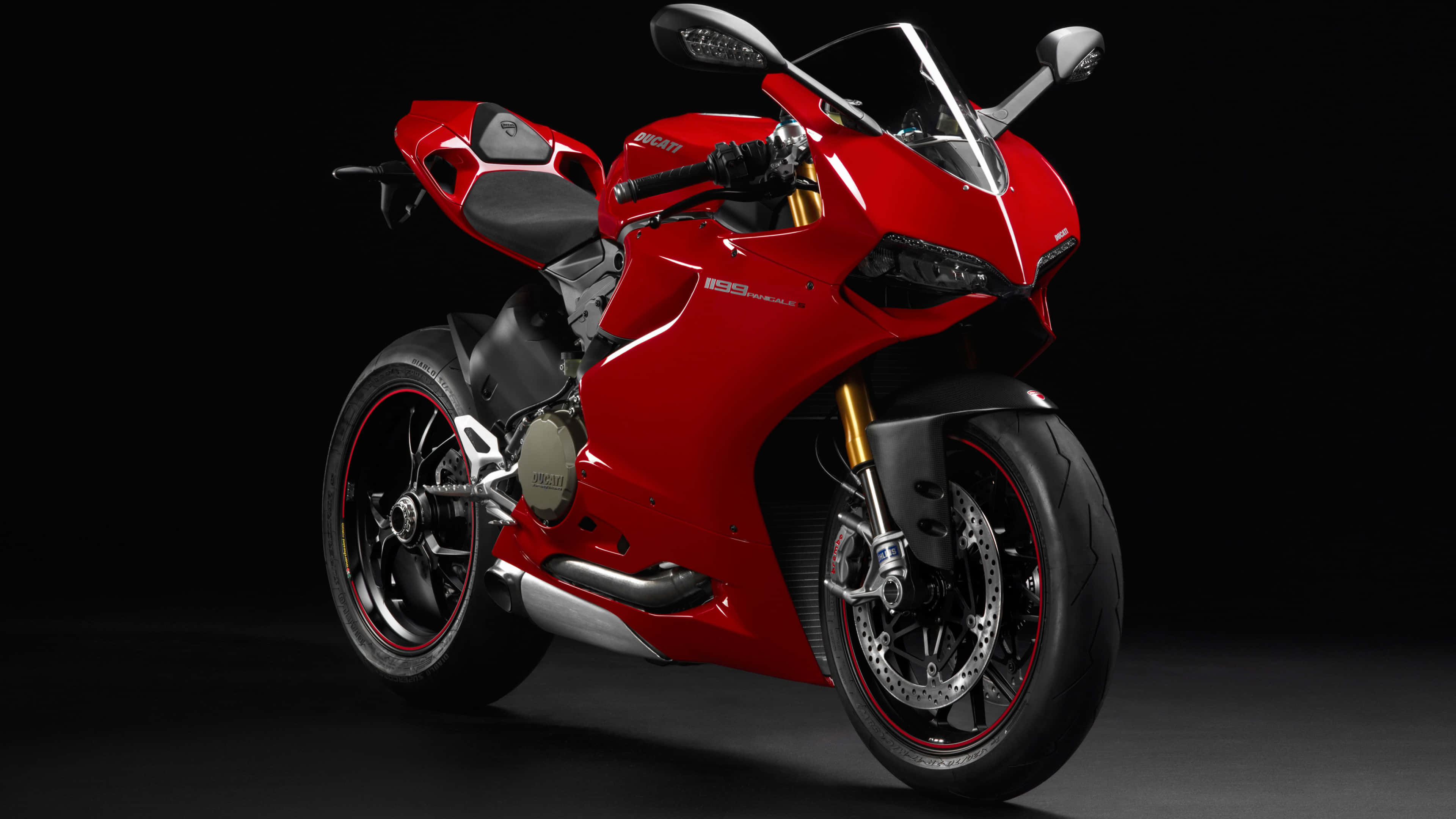 Superbike 桌布 壁紙 — 一台線條流暢的紅色Ducati機車，配備金色前叉和黑色飾件，在深色攝影棚背景前蓄勢待發。