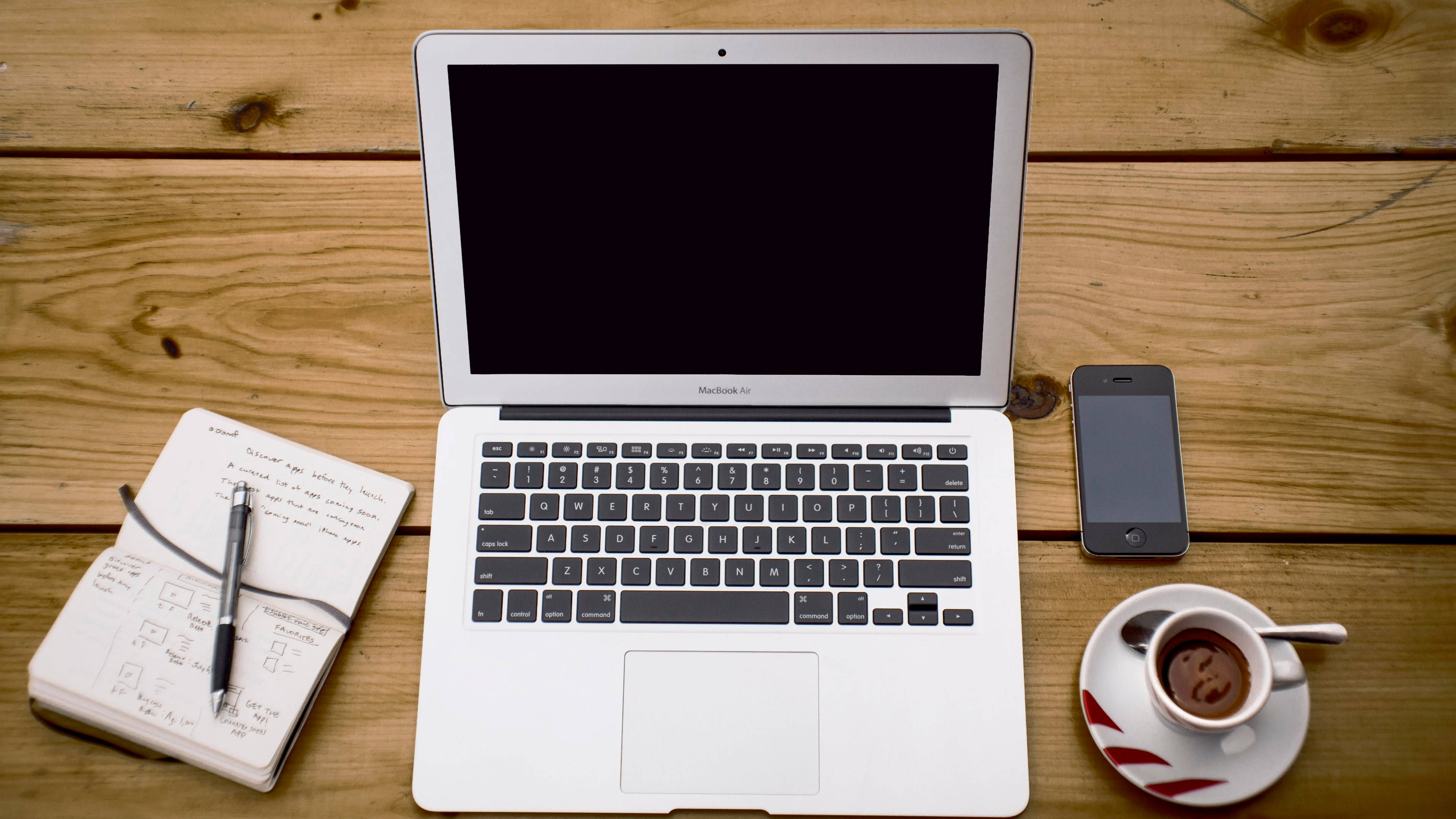 MacBook 動態圖片 桌布 壁紙 — 一台銀色筆記型電腦和咖啡杯放在溫暖的木桌上，準備好工作或學習。