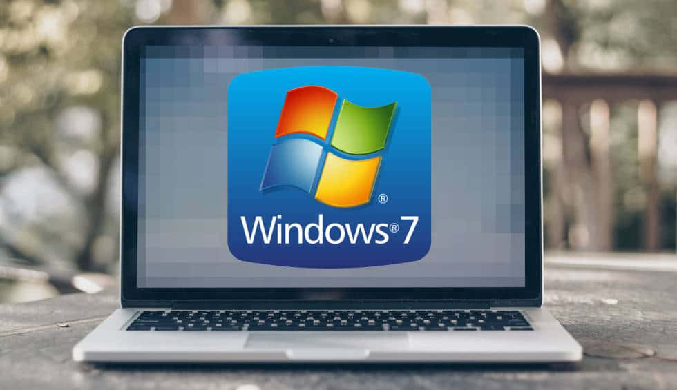 Windows 7 桌布 壁紙 — 一台銀色筆記型電腦在戶外木質表面上，螢幕上顯示Windows 7標誌。