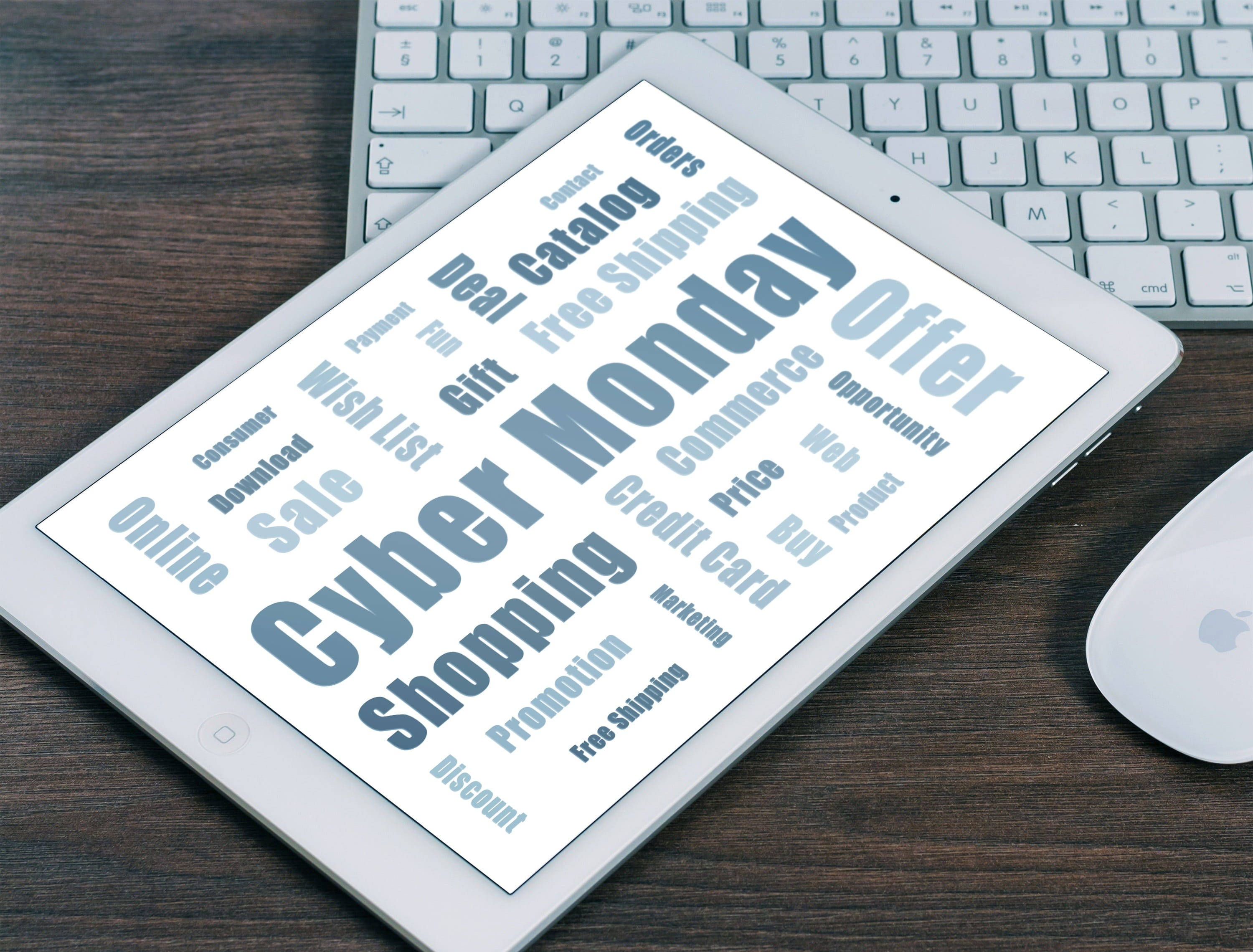 科技動圖 桌布 壁紙 — 一台顯示「Cyber Monday」銷售字詞的平板電腦放在木桌上，旁邊有鍵盤和滑鼠。