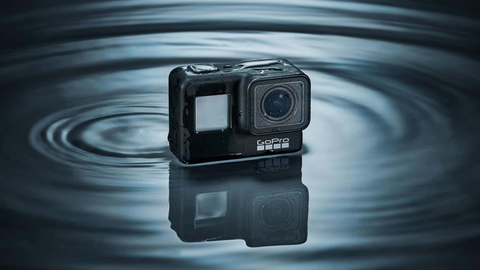 gopro 桌布 壁紙 — 一台黑色GoPro相機漂浮在水中，周圍有同心圓漣漪向外擴散。