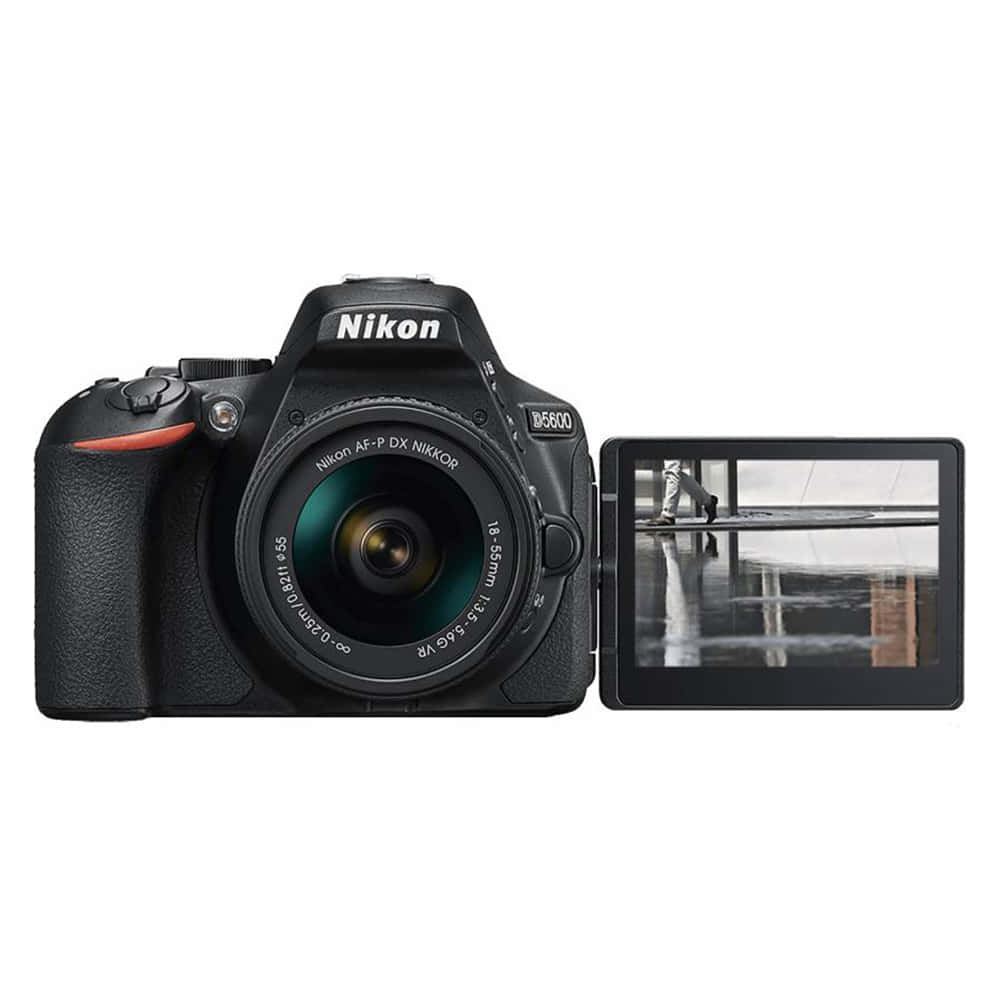 Dslr Camera 桌布 壁紙 — 一台黑色Nikon D5600 DSLR相機，配備18-55mm鏡頭和翻轉螢幕，顯示一張黑白照片，照片中一個人在潮濕表面上行走。