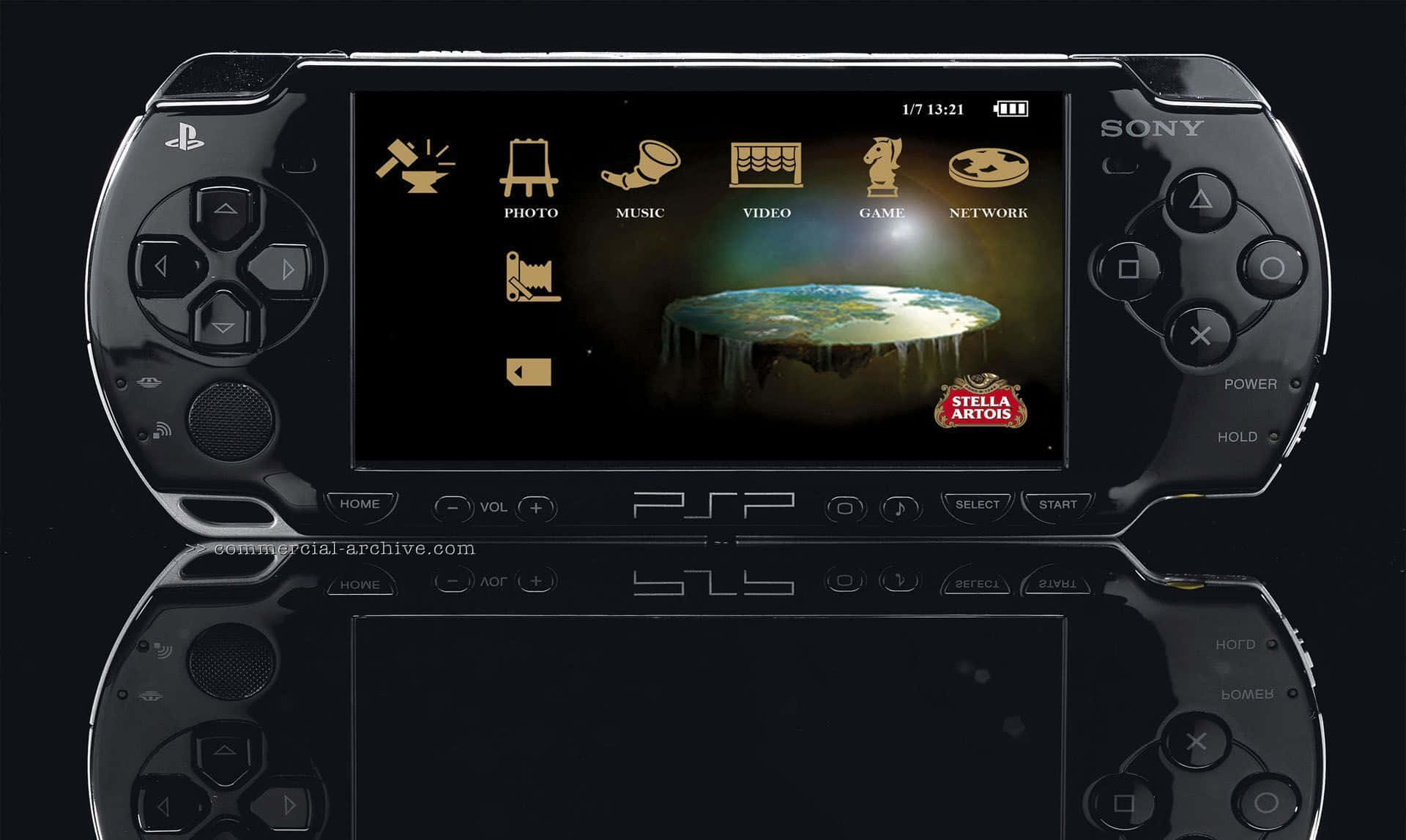 Psp 桌布 壁紙 — 一台黑色Sony PSP主機在深色背景上顯示一個發光的地球狀球體，帶有Stella Artois標誌。