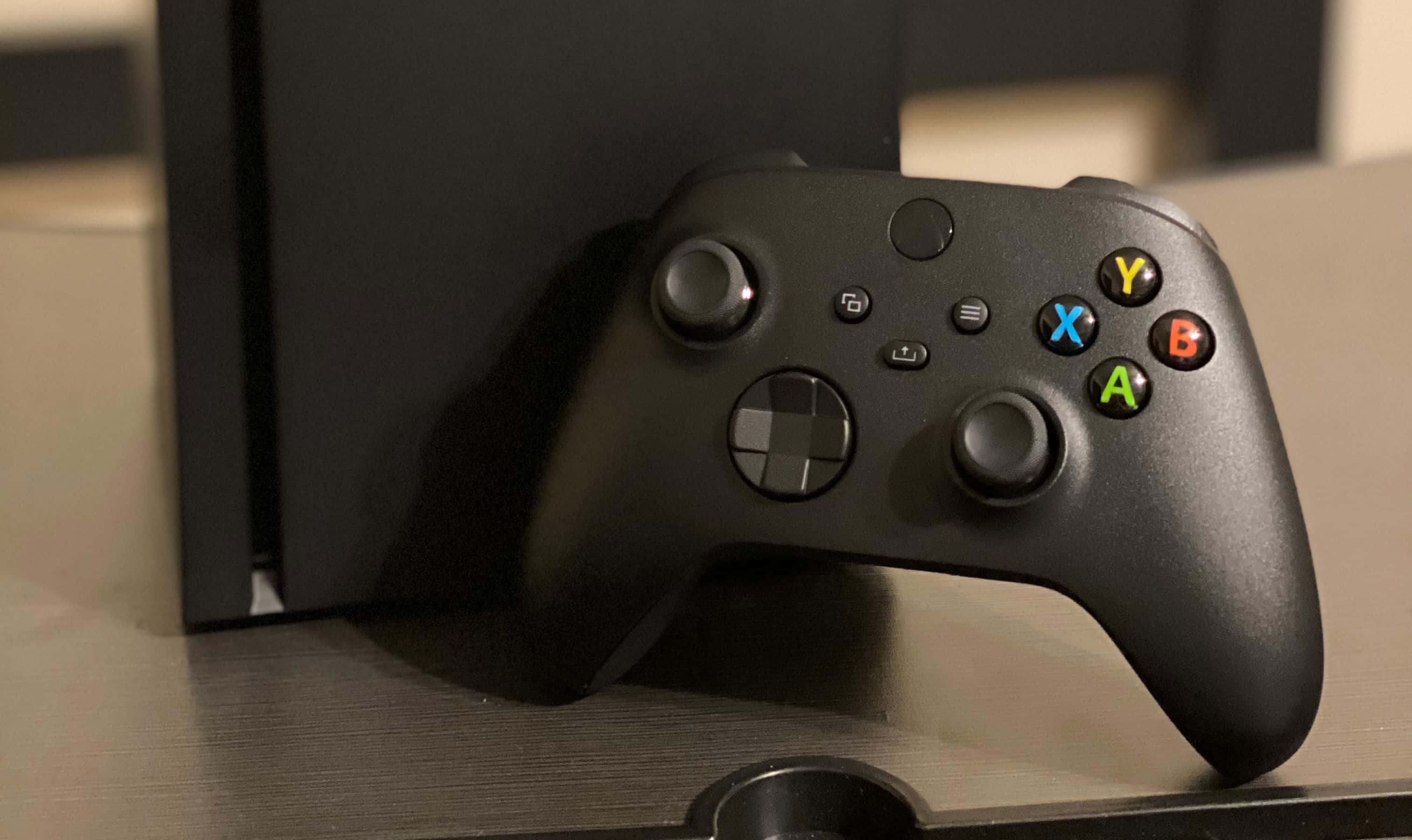 一台黑色Xbox One主機放在桌上 壁紙