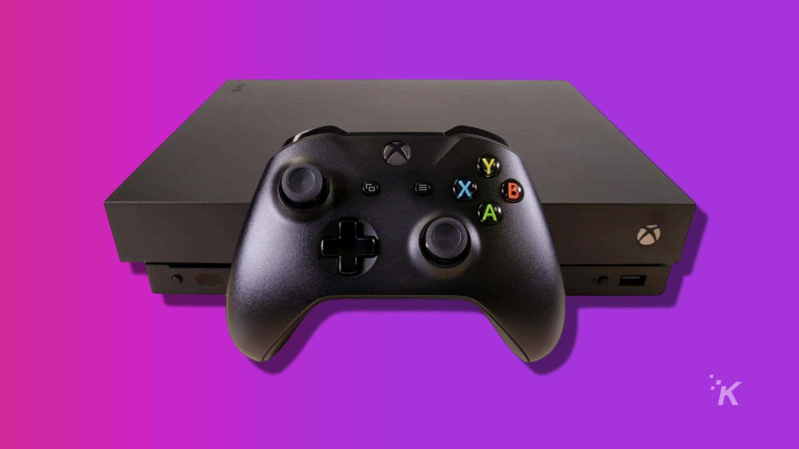 Xbox 桌布 壁紙 — 一台黑色Xbox主機和控制器居中放置在充滿活力的紫色和粉紅色漸變背景上。