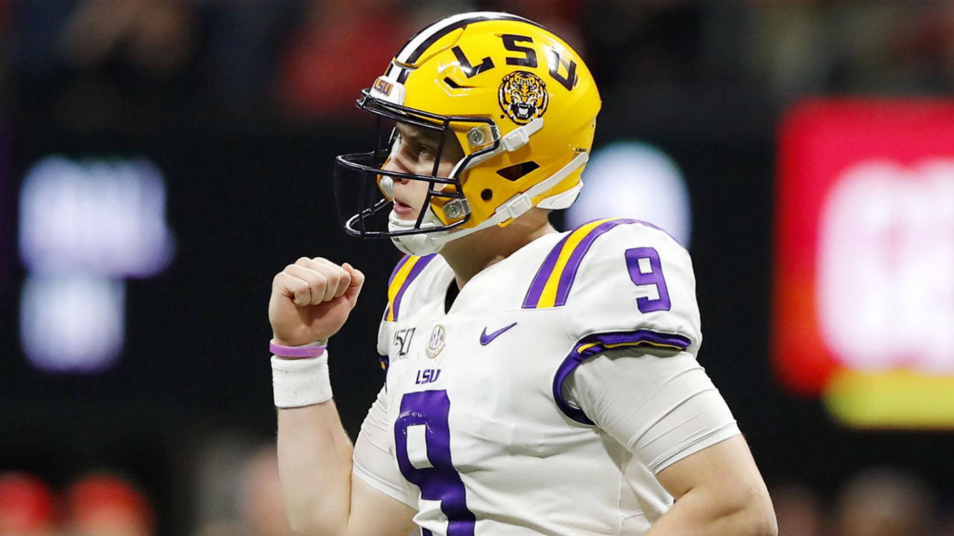 Joe Burrow 桌布 壁紙 — 一名LSU足球員戴著黃色頭盔、身穿白色9號球衣，在夜間比賽中握拳慶祝勝利。
