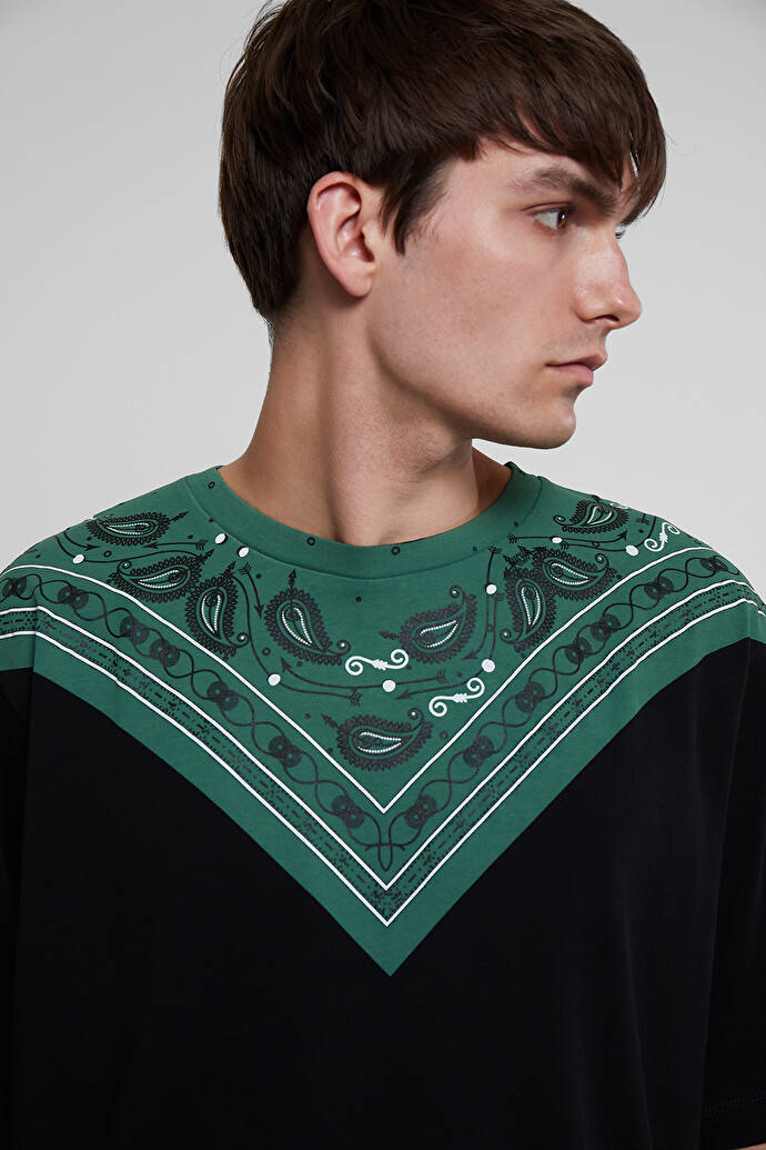 Fashion Model 桌布 壁紙 — 一名側面男子穿著黑色襯衫，帶有綠色佩斯利花紋領子，背景為純灰色。