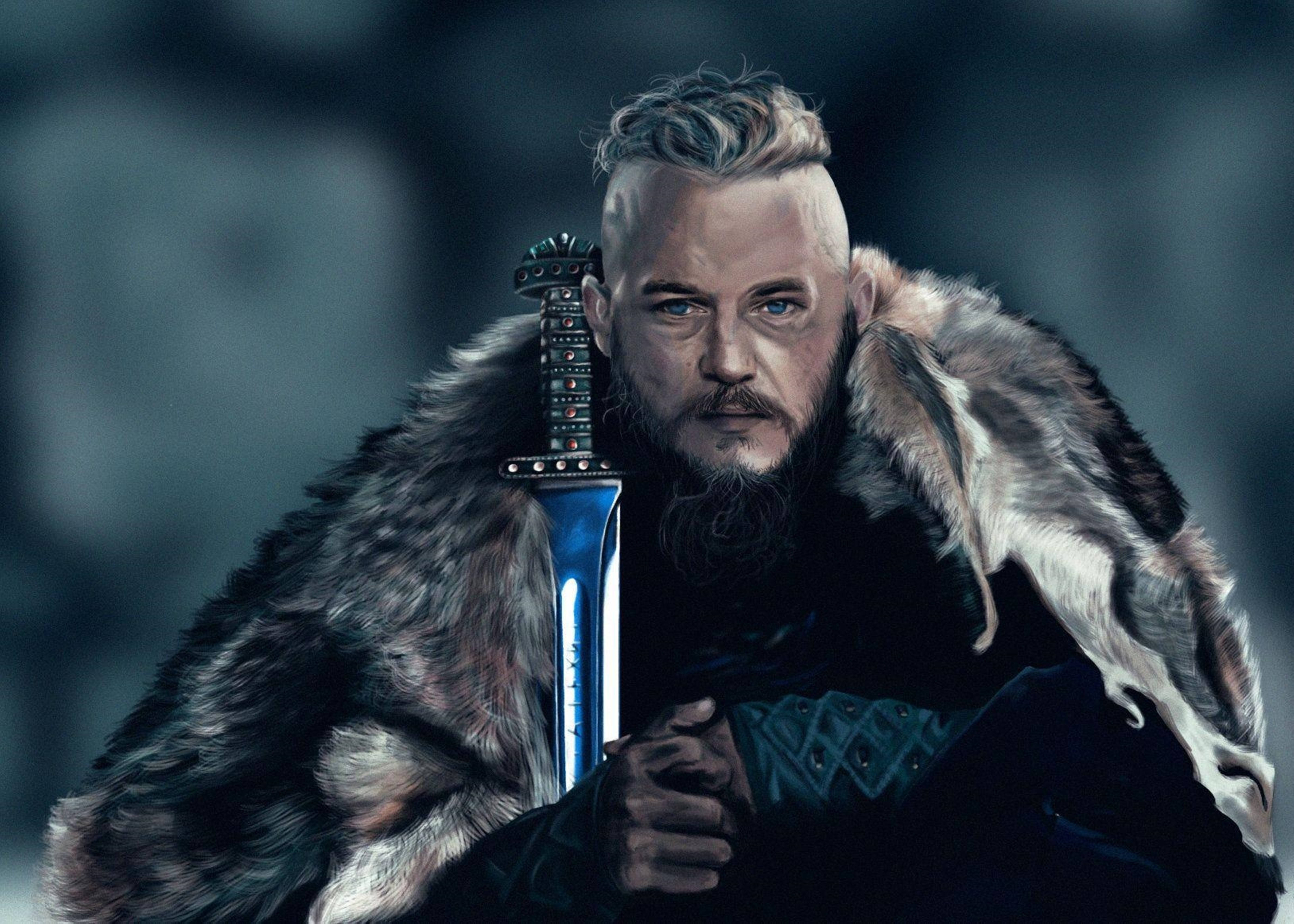Vikings 桌布 壁紙 — 一名兇猛的維京戰士手持藍色劍，身披毛皮斗篷，在模糊的冰雪背景下凝視著。