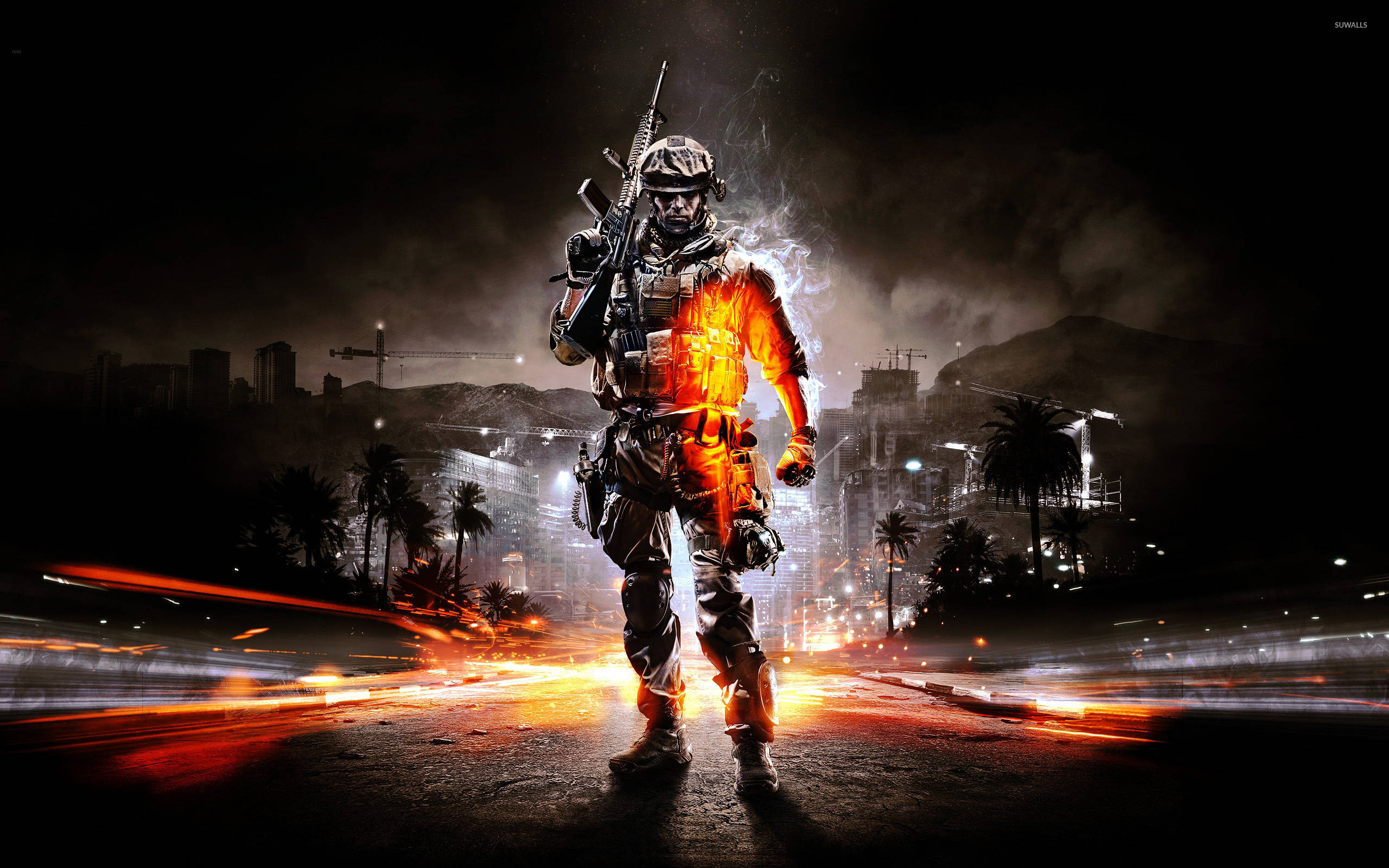 Battlefield 3 桌布 壁紙 — 一名全副武裝的士兵在夜晚的熾熱城市戰場上，胸口散發出橙色光芒的能量，挑釁地站立著。